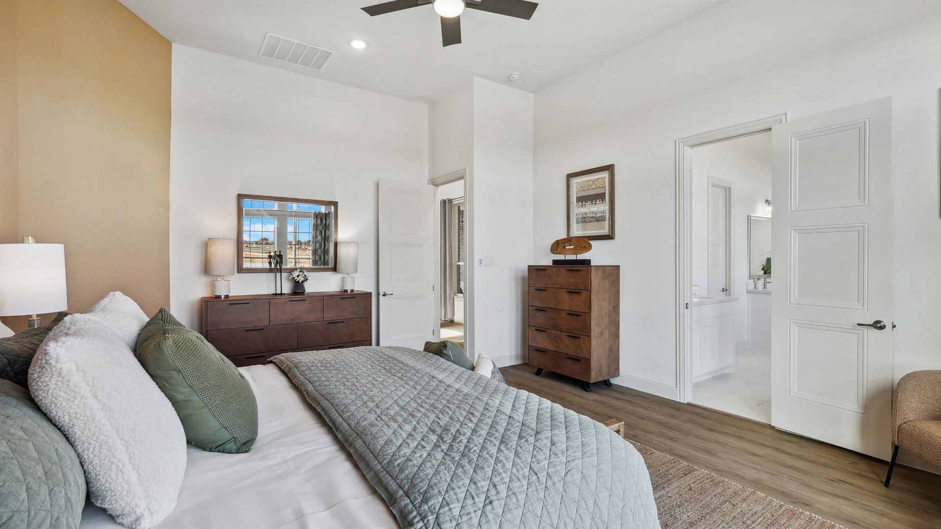 Luxurious Solterra bedroom with sleek wood flooring, elegant neutral palette, and stylish ceiling fan.