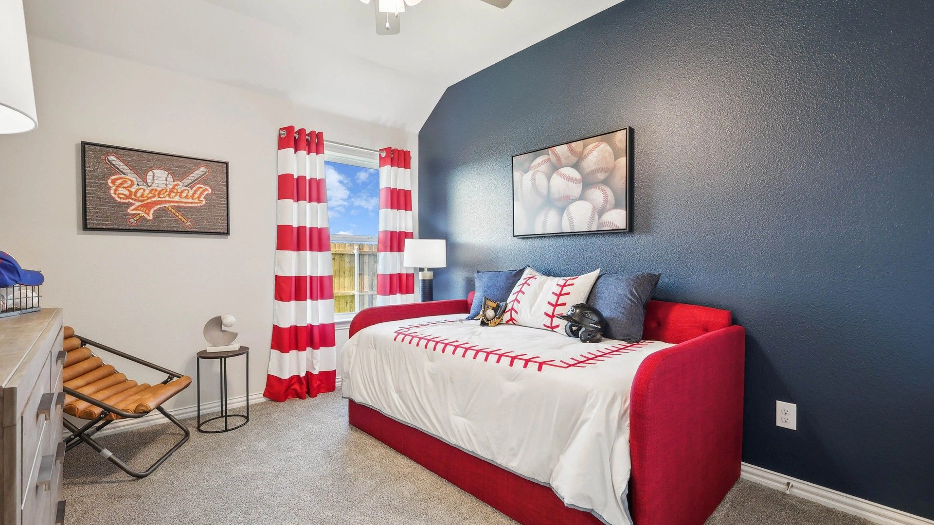 Luxurious Pebblebrook bedroom with bold navy accent wall, tailored red daybed, and sporty decor.
