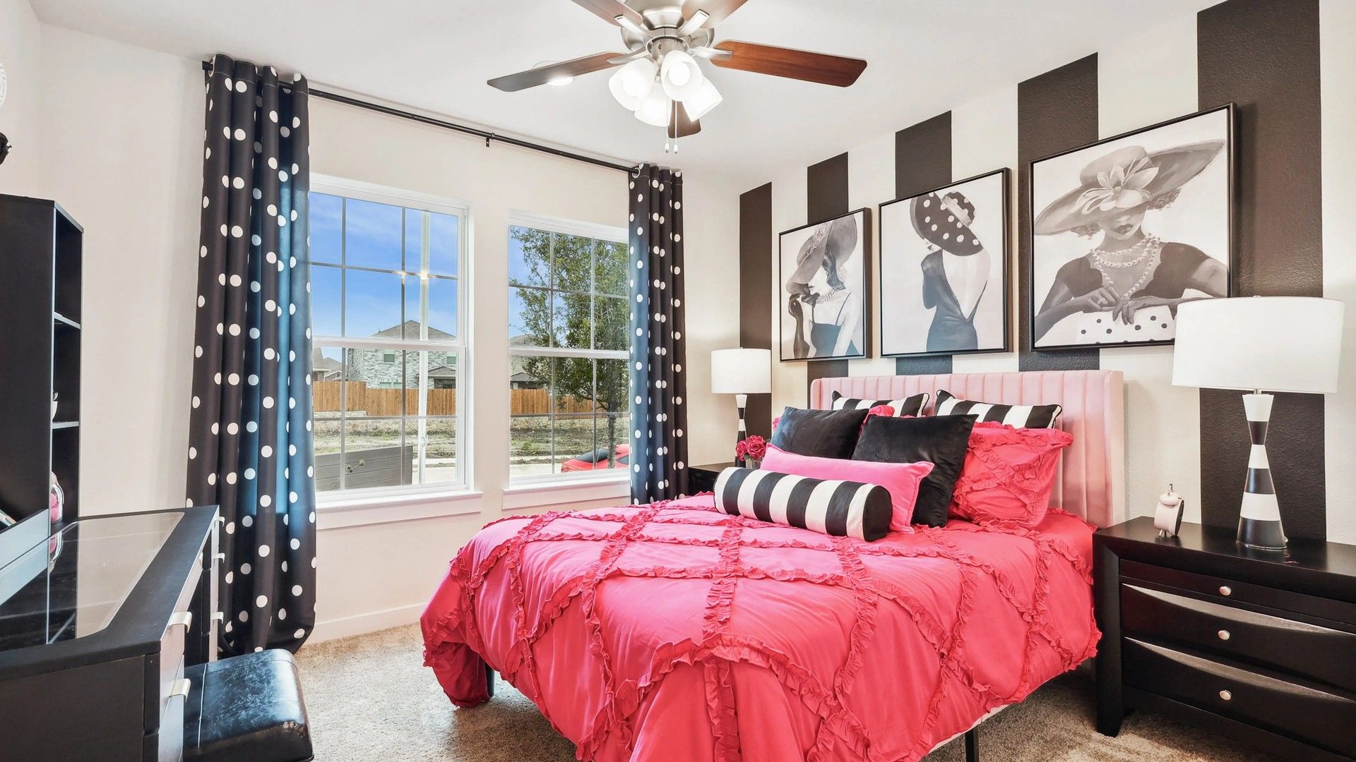 Simpson Crossing's bedroom features chic pink bedding, striped wall art, and elegant polka dot accents.