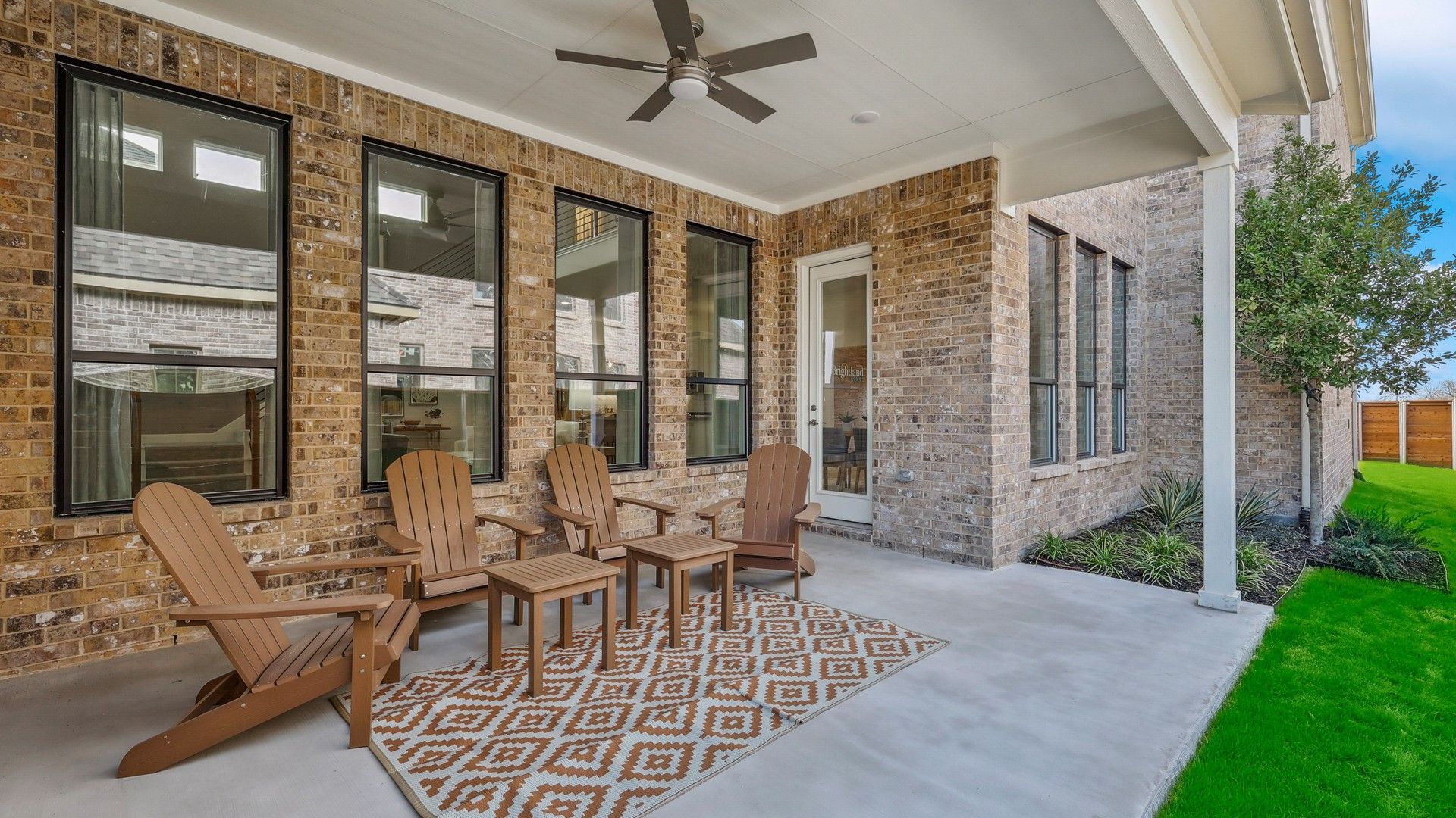 Sophisticated covered patio with brick masonry and sleek ceiling fan in Solterra, Texas.