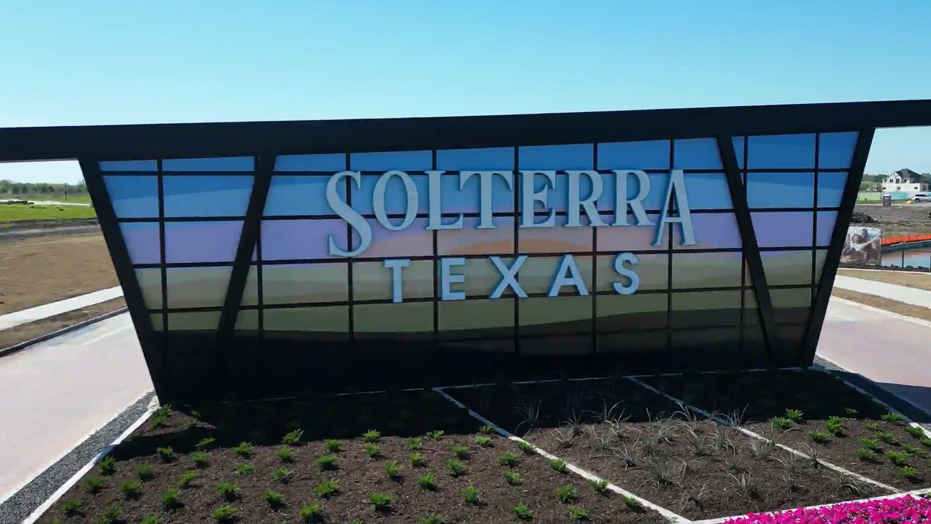 Experience Solterra Texas: Modern architecture with angular glass design, surrounded by lush landscaping.
