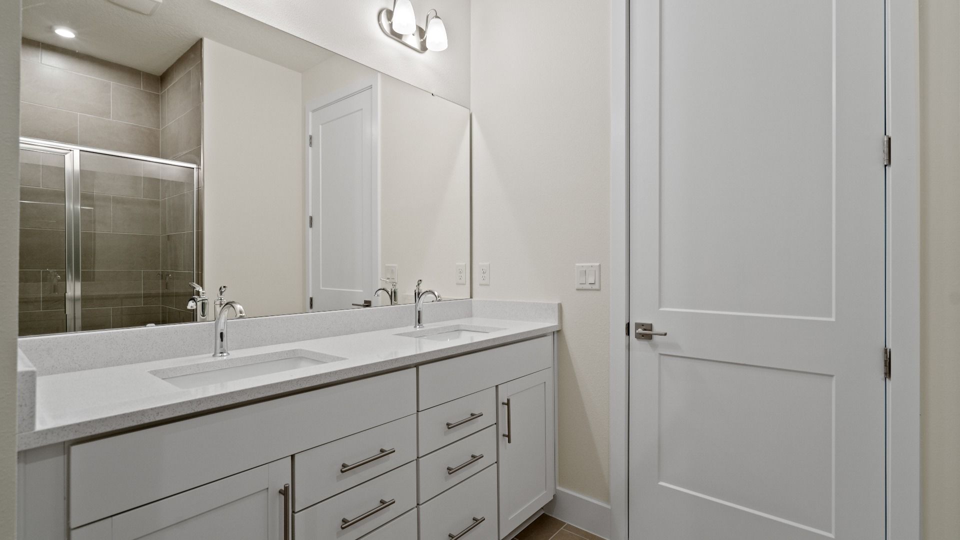 Primary En Suite Bath with Dual Sinks and Walk-In Glass Encased Shower in the Longleaf by DRB Homes New Home in Saint Cloud