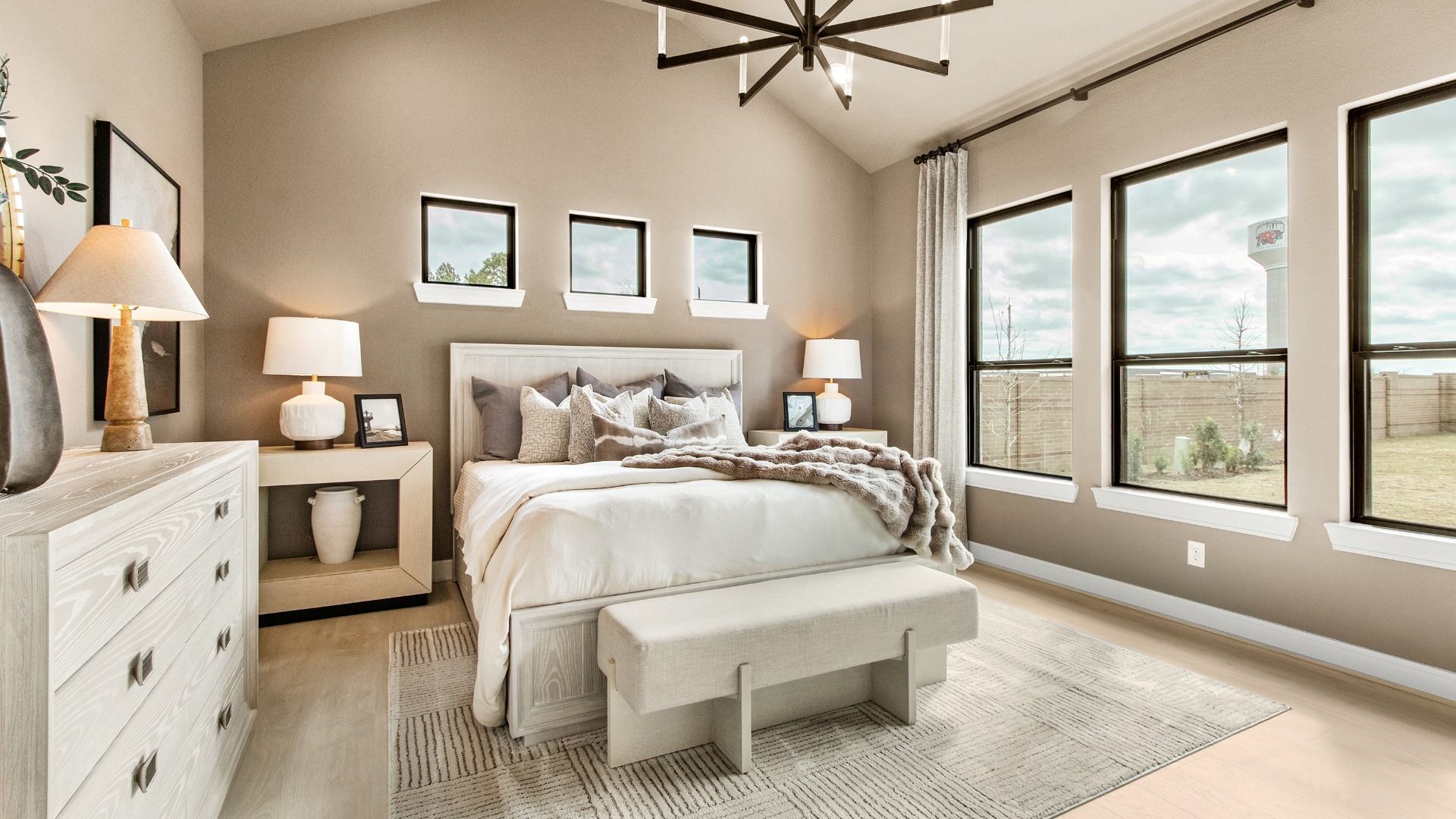 Large windows fill this primary bedroom in Bridgeland Central with natural light.
