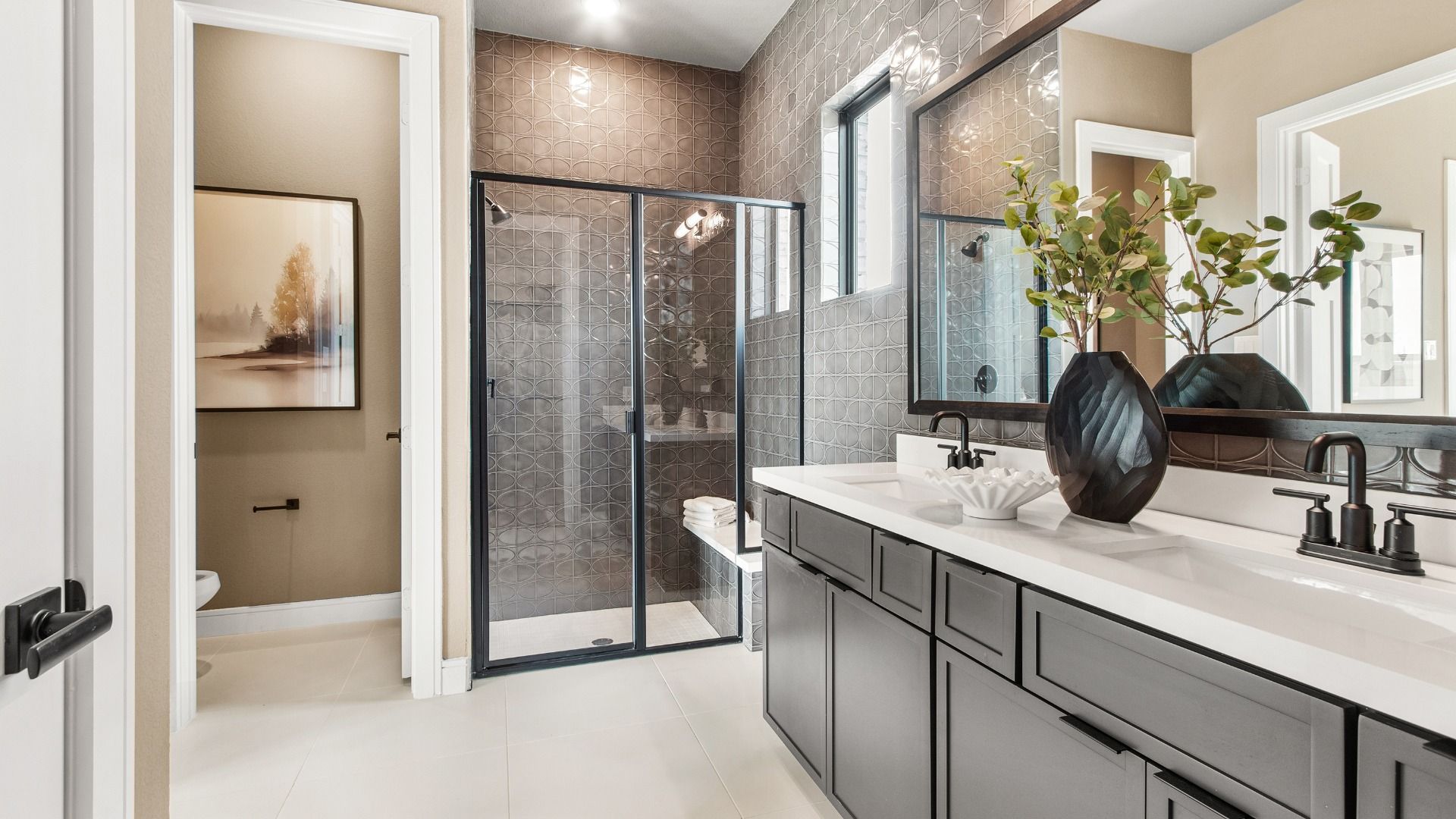 Walk-in shower with built-in seat and grey tile wall create a modern bathroom in Bridgeland Central