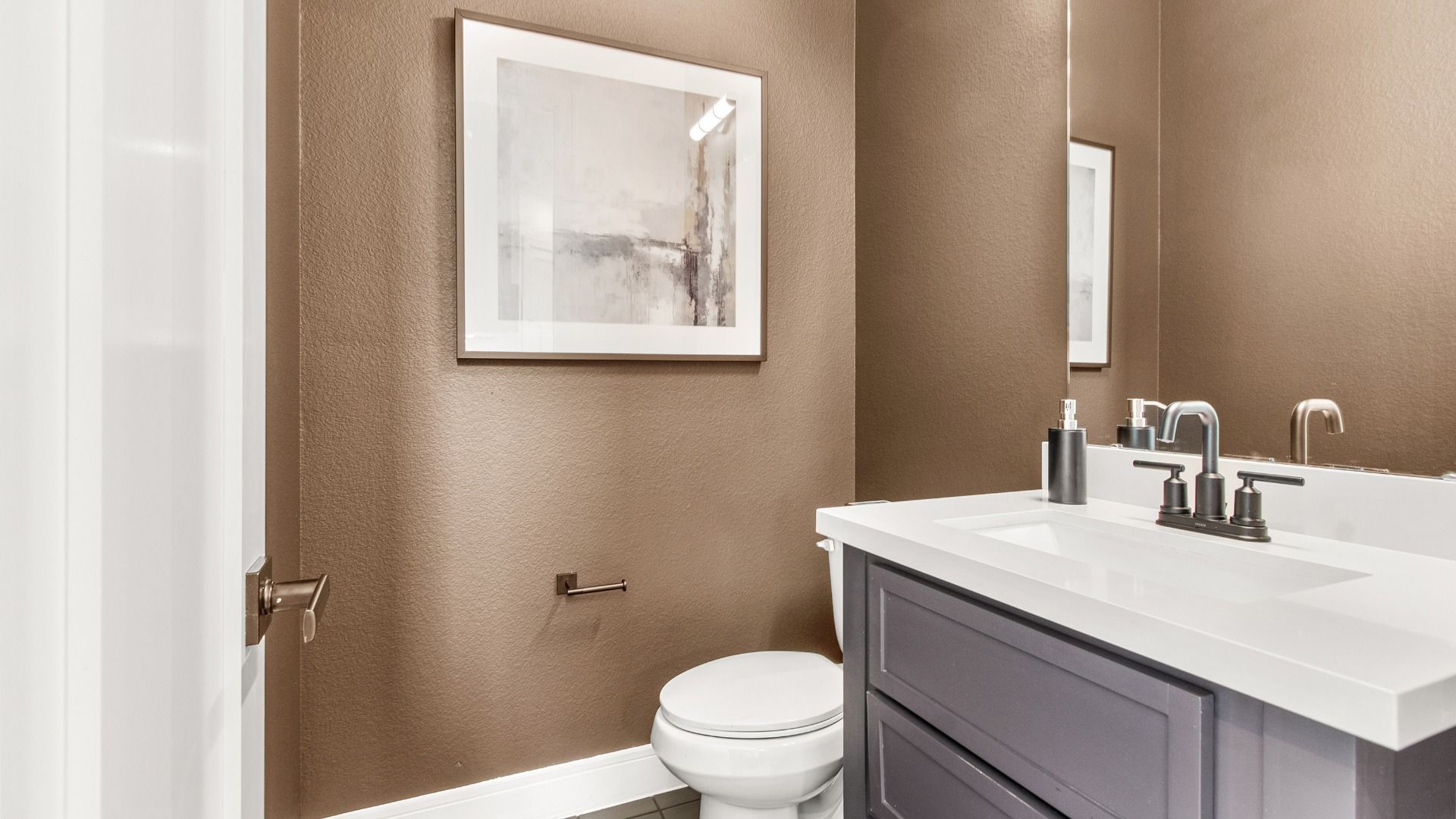 This powder room in Bridgeland Central features bold black cabinetry and crisp white counters.