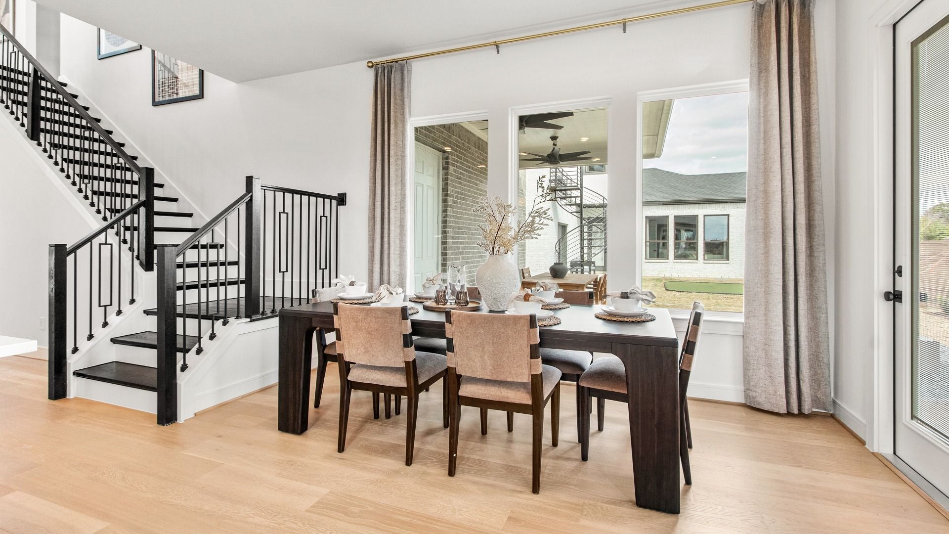 Bright dining space in Bridgeland Central framed by stairs and expansive windows.