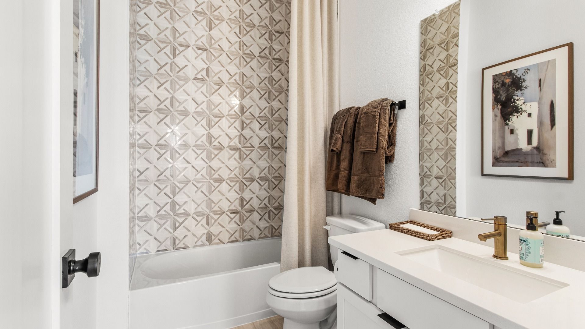 This bathroom in Bridgeland Central features geometric tile and crisp white cabinetry.