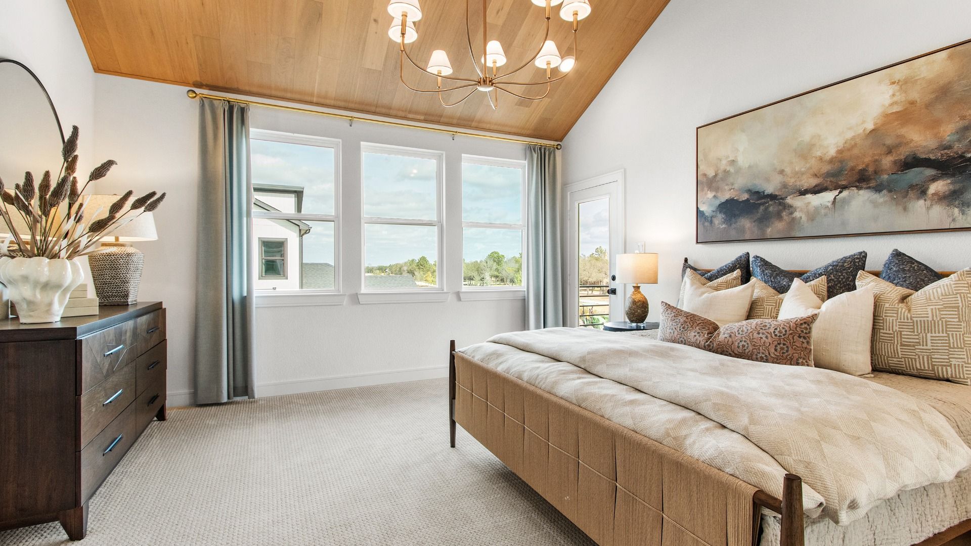 White walls and a warm-toned ceiling highlight this bedroom in Bridgeland Central with balcony access.