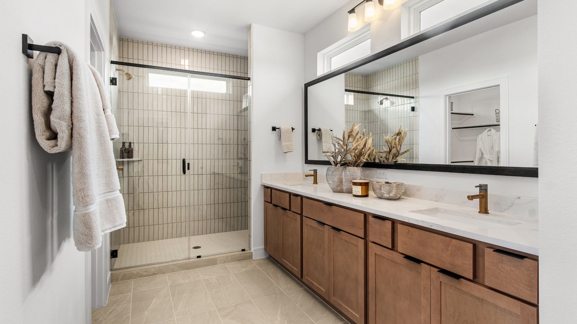 Warm cabinetry and beige tile shower wall create a soft modern bath in Bridgeland Central.
