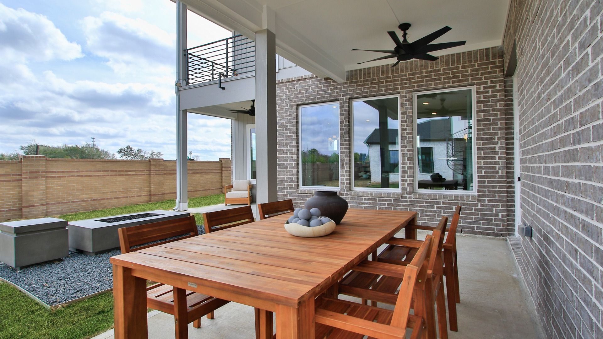 Covered patio in Bridgeland Central with outdoor dining and ceiling fans for comfort.