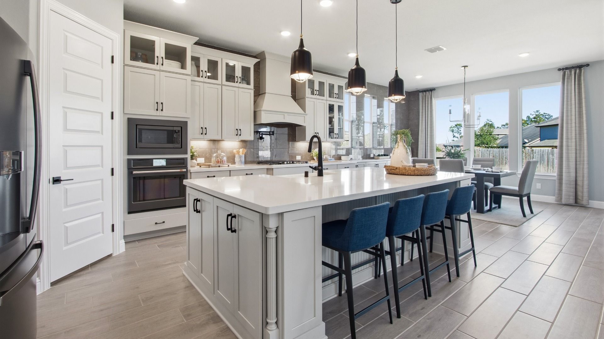 Elegant cabinetry and quartz island enhance this kitchen's luxurious ambiance in Mostyn Manor Reserve.