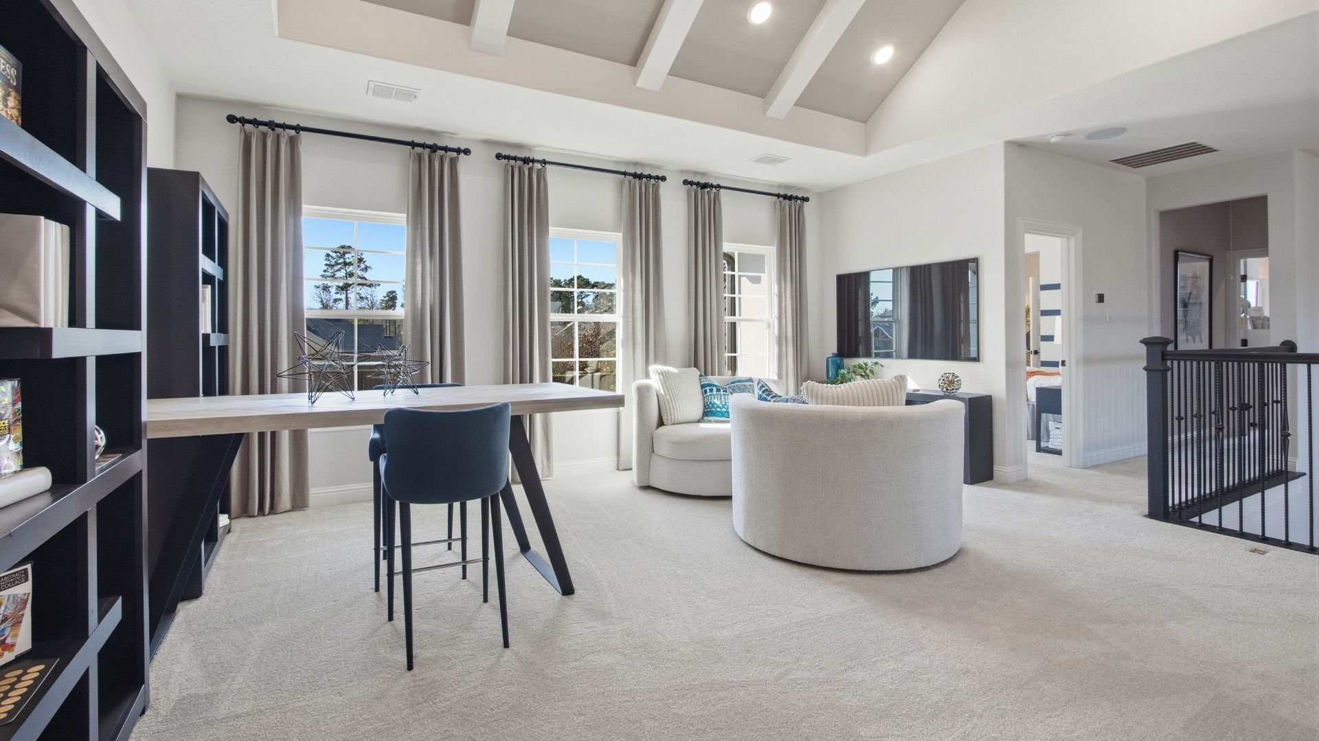Sophisticated vaulted ceiling and vibrant blue drapery define this chic space in Mostyn Manor Reserve, Texas.