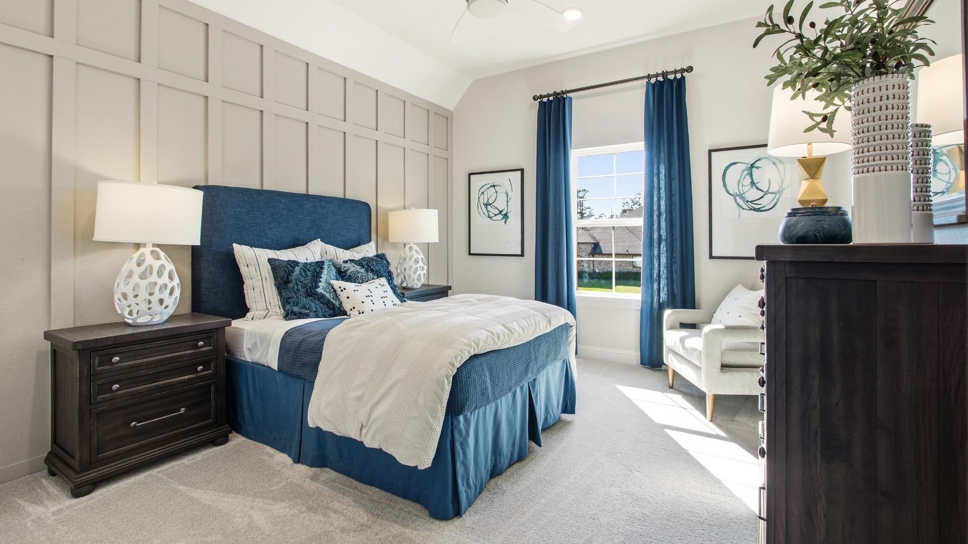 Generously sized guest room with decorative trim and abundant sunlight