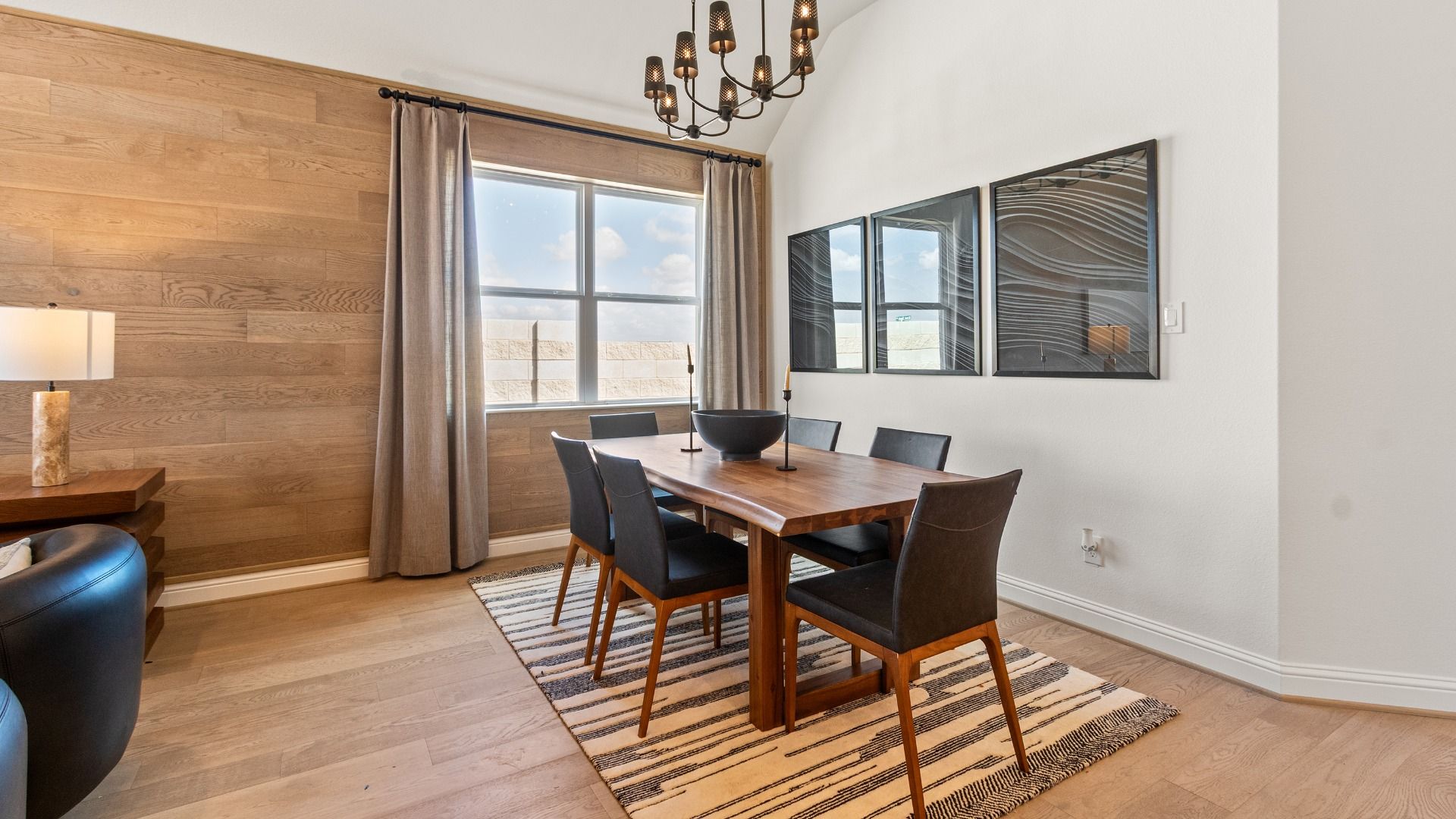 Exquisite accent wall highlights contemporary chandelier and wood finishes in River Ranch.