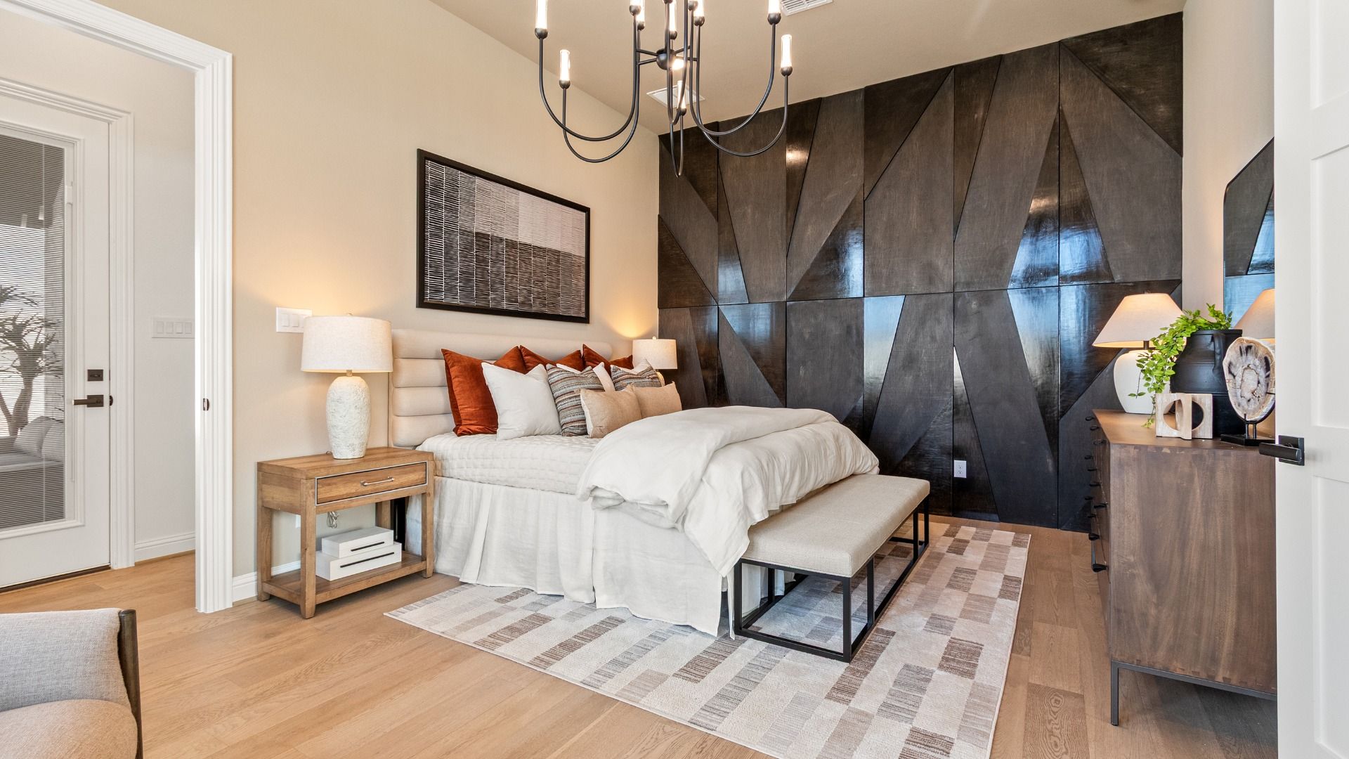 Experience luxury with a sleek black accent wall and sophisticated chandelier in River Ranch.
