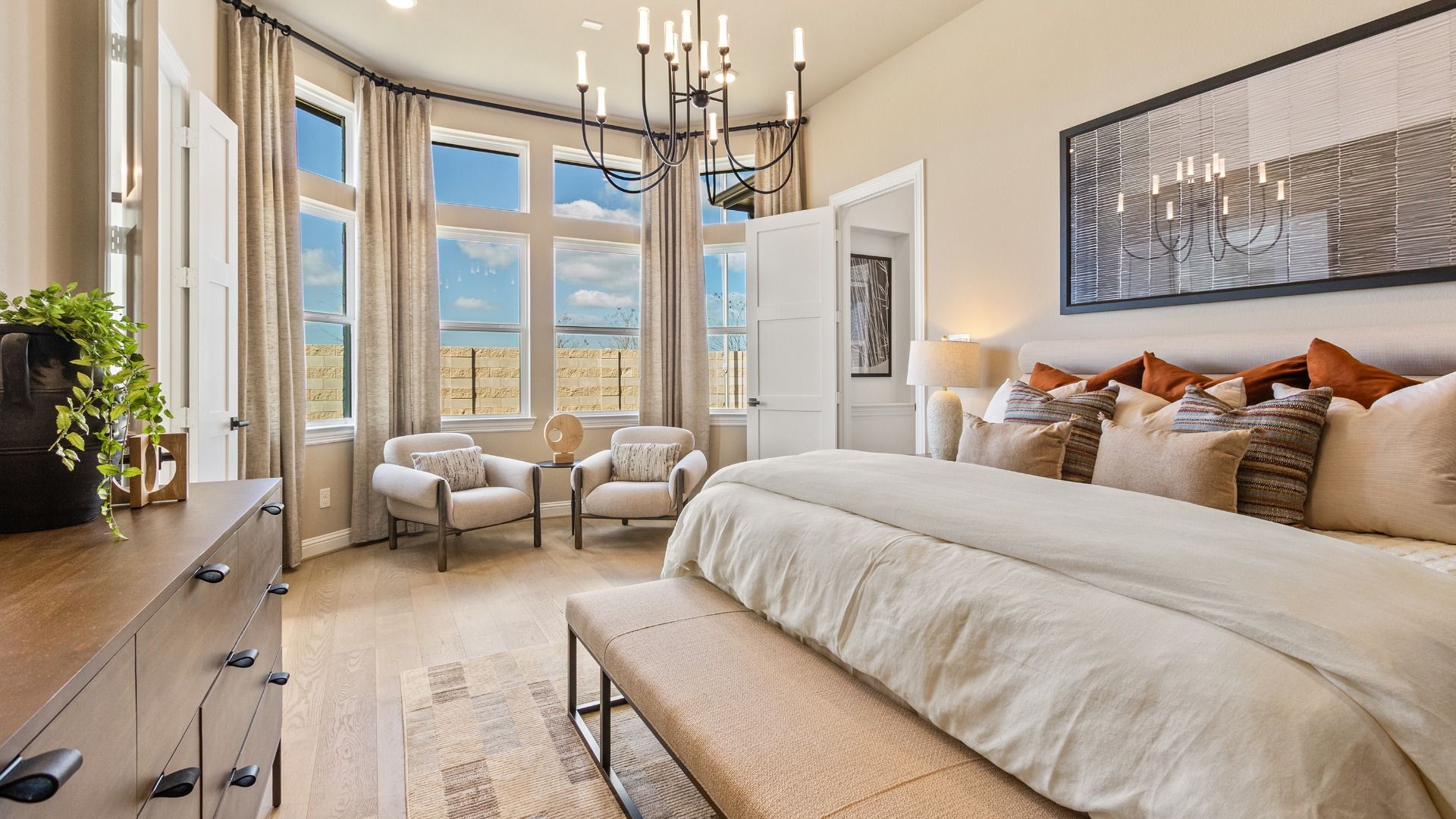 Luxurious River Ranch bedroom with a striking bay window and stylish modern chandelier.