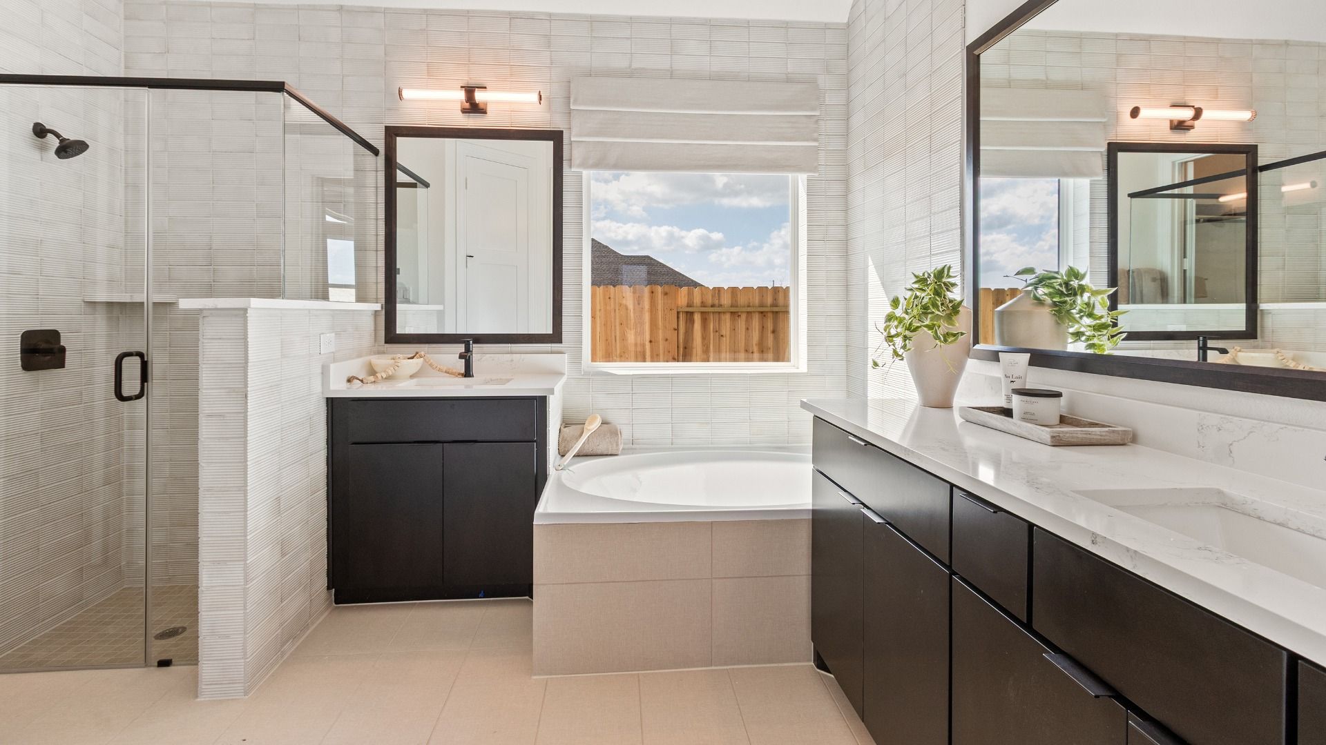 Elegant dark cabinetry, durable tile flooring, and sleek fixtures elevate this River Ranch bathroom retreat.