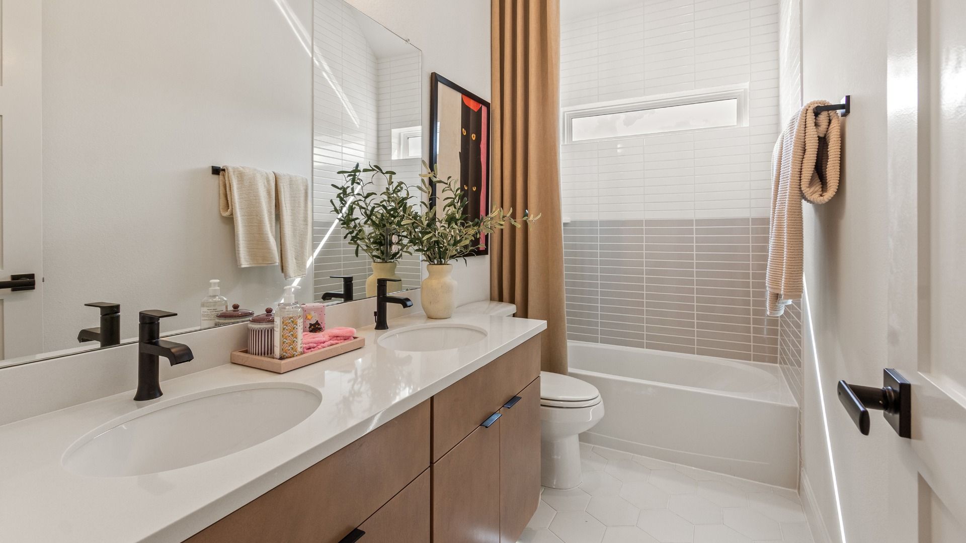 Experience elegance with custom wood vanity and exquisite tile accents in River Ranch.