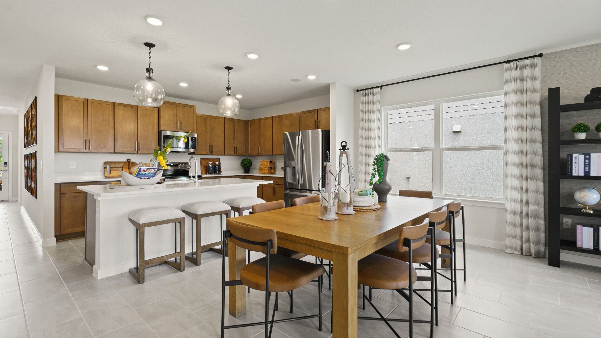 Modern Farmhouse Style Model Home Kitchen open concept Interior by DRB Homes with brown cabinets.