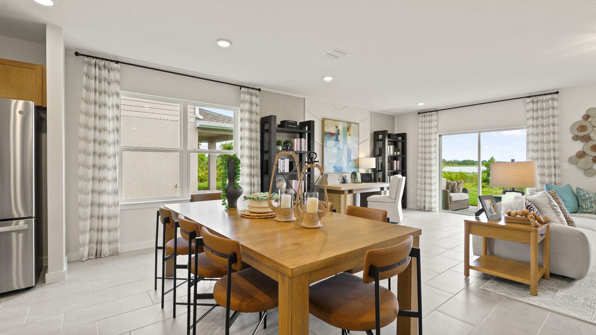 Modern Farmhouse Style Model Home dining area in the open concept Interior by DRB Homes with brown cabinets.