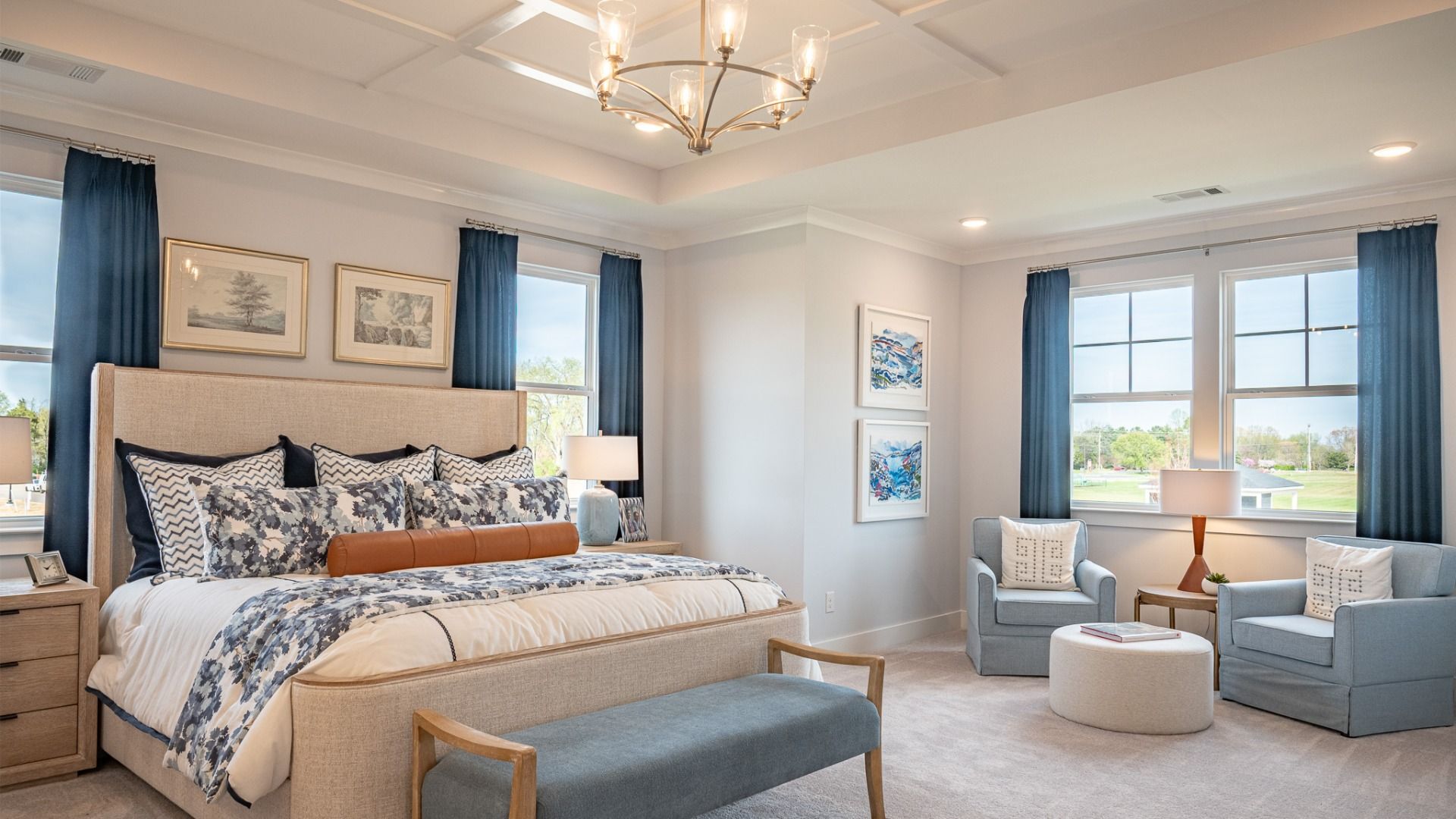 Oversized bedroom with dedicated seating area, accent trim tray ceiling, and king-sized bed