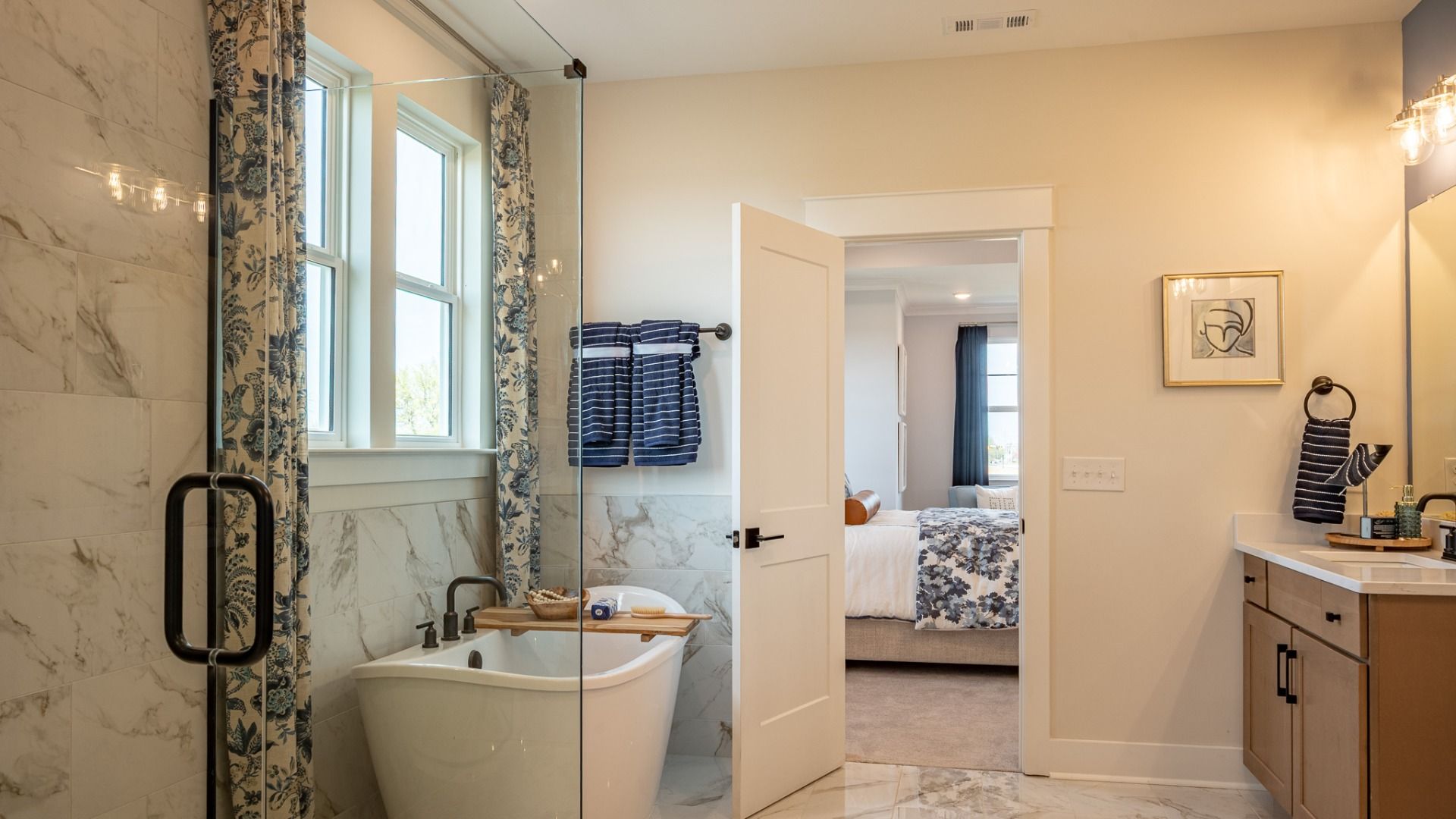 Bright bathroom with frameless glass shower and full tile, separate freestanding tub, and large closet