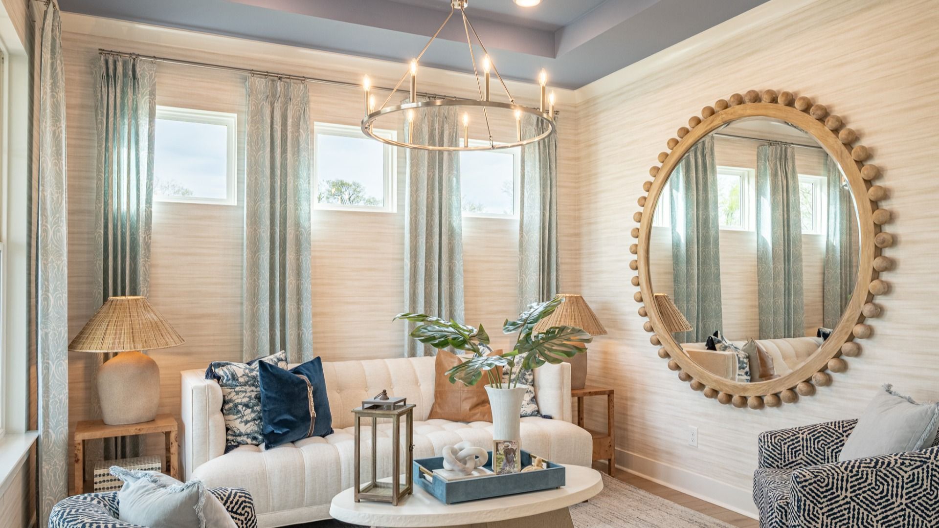 Seating area near front of home with tray ceiling and designer furnishing