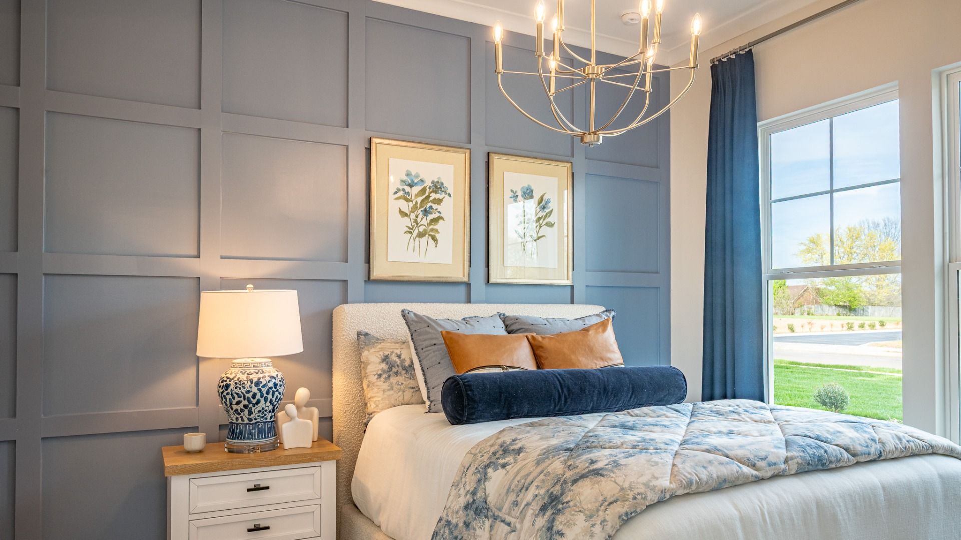 Bedroom with large windows, blue accent trim wall, and hanging light fixture