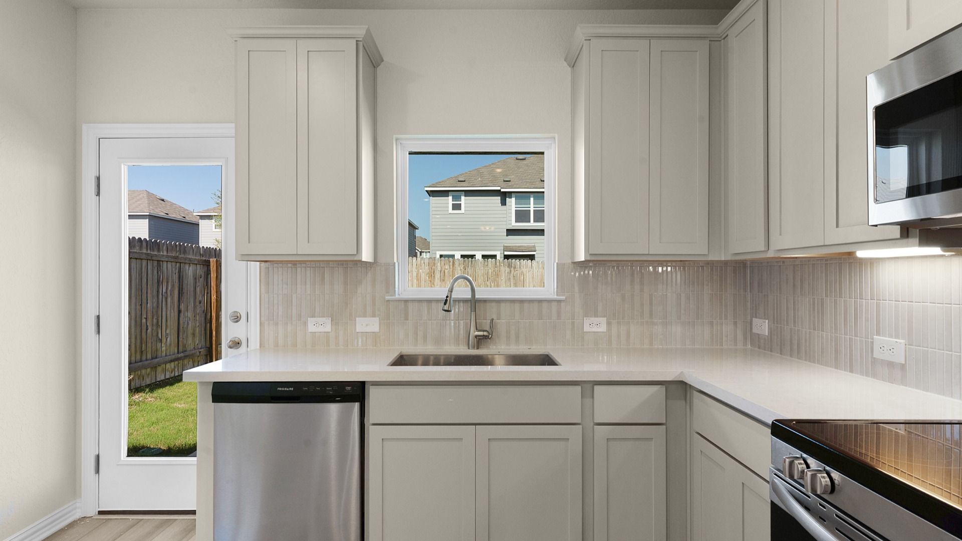 Kitchen featuring 42" painted cabinets, under cabinet lighting, and mosaic backsplash tile