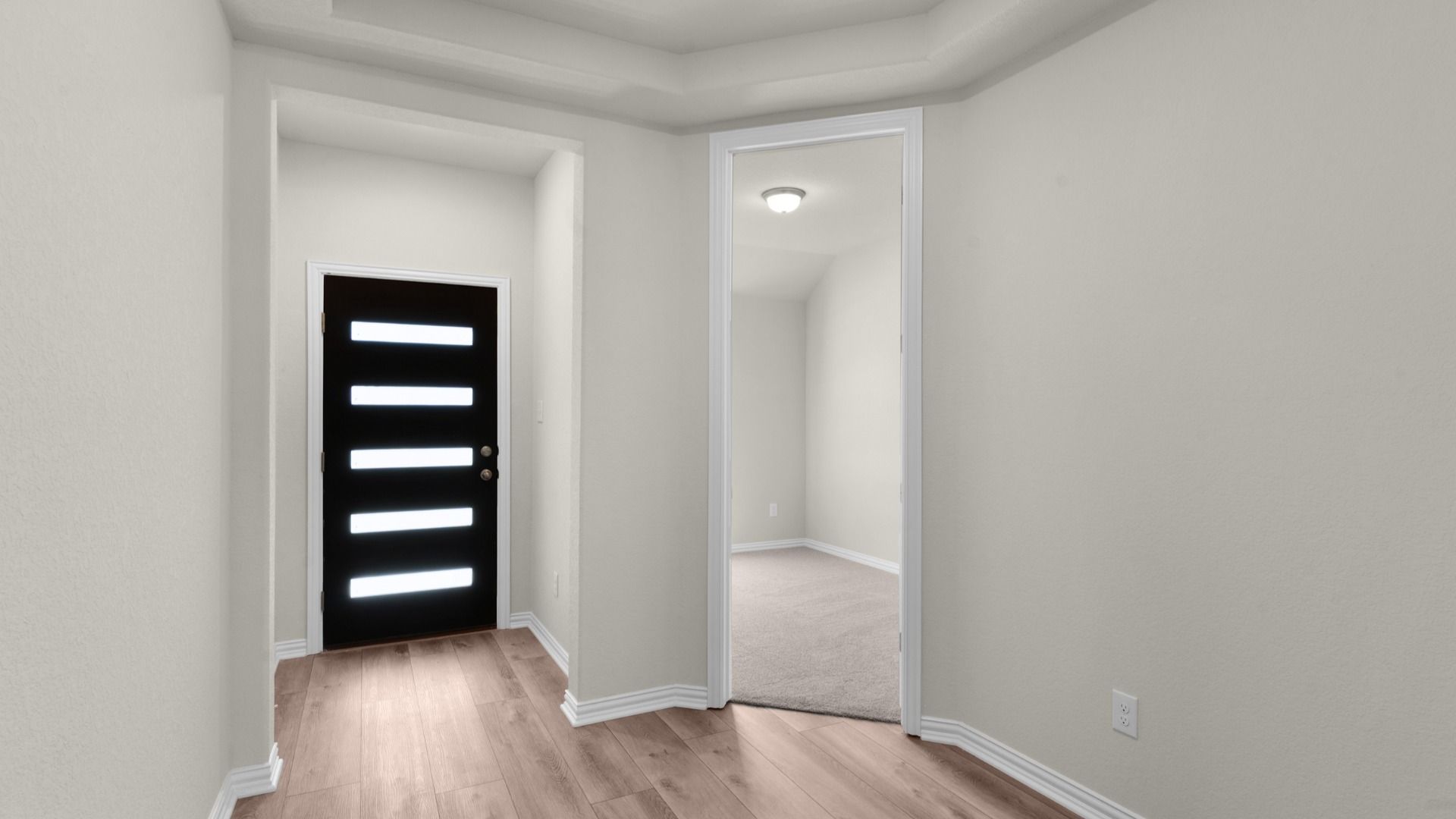 Entryway of the home with raised ceiling