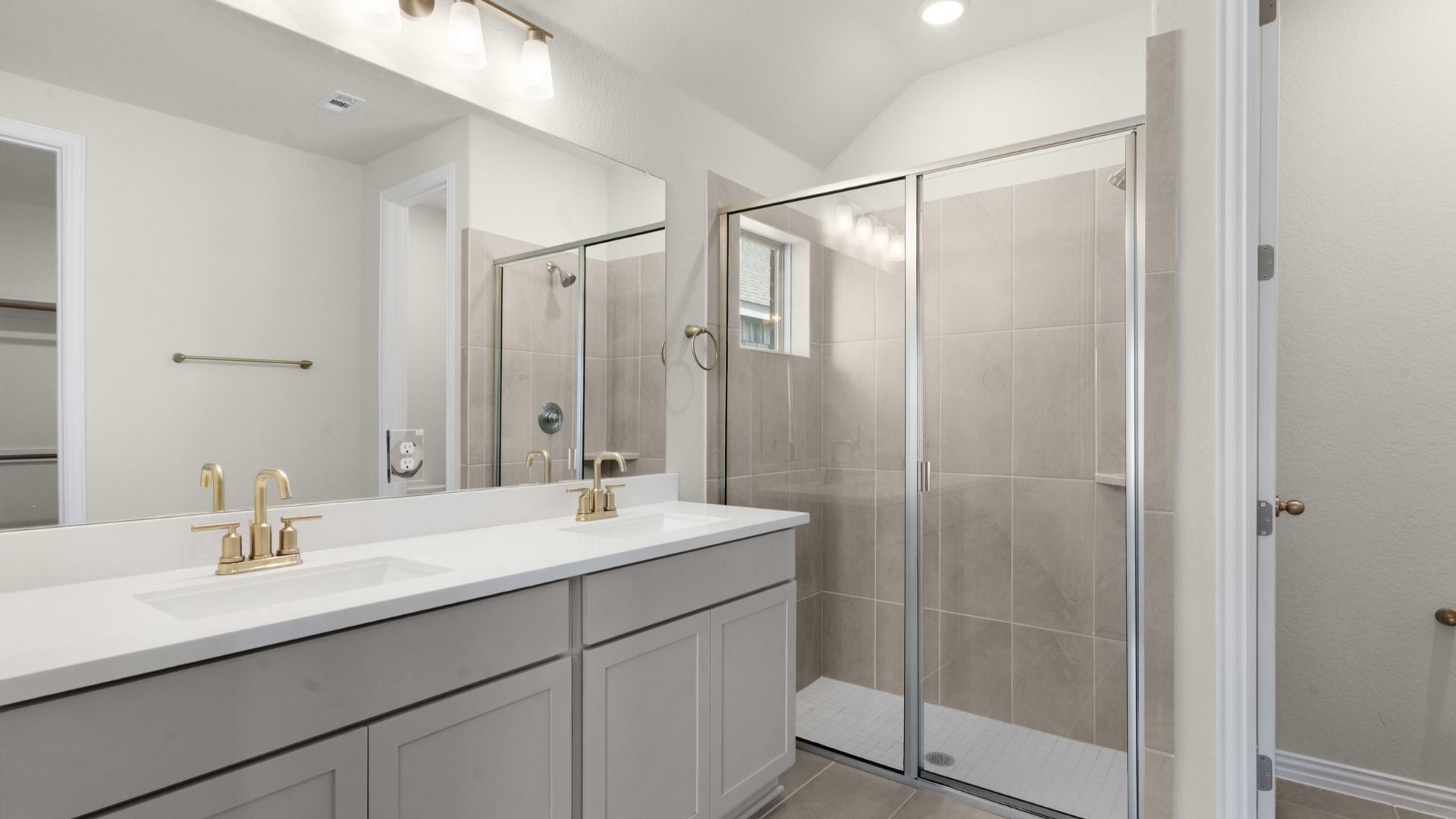 Owner's Bathroom featuring ceramic tile shower & a dual vanity