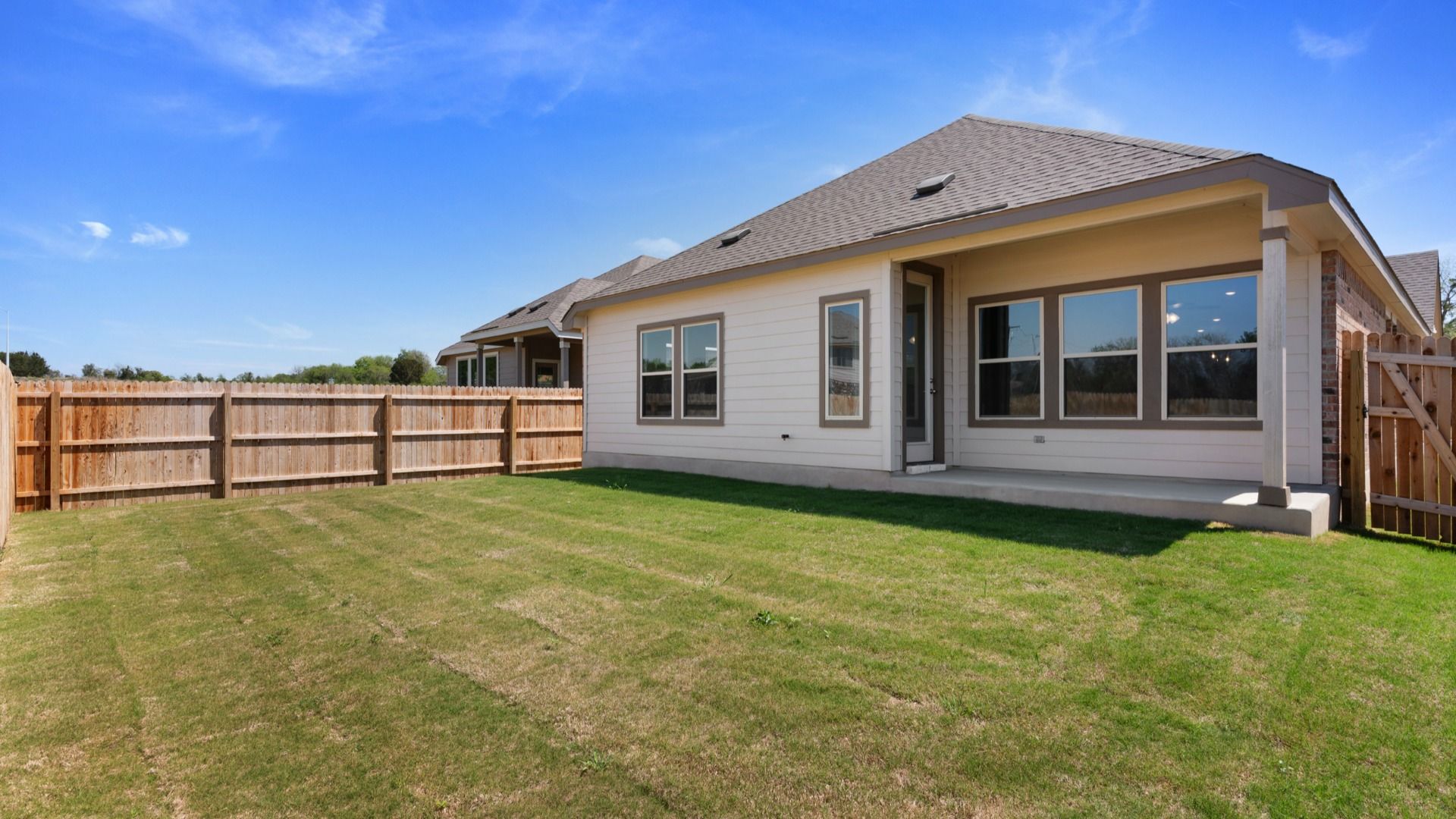 Backyard lined with privacy fence and one gate
