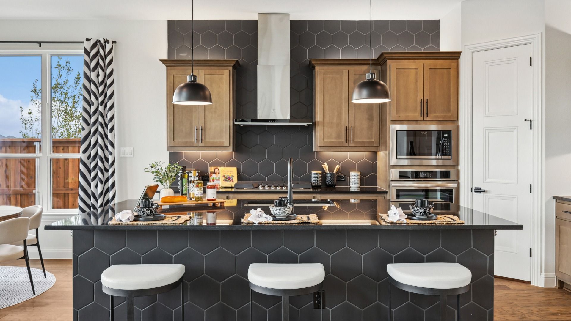 Sophisticated kitchen with sleek black hexagonal tiles and custom wood cabinetry in Green Meadows.