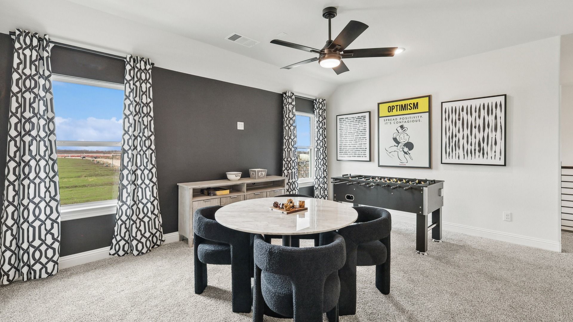 Luxurious game room with sleek ceiling fan, marble table, and panoramic views in North Texas.