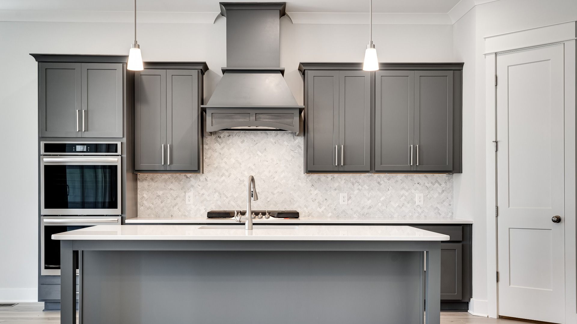 Kitchen with gray cabinets and modern style with tile backsplash and range hood