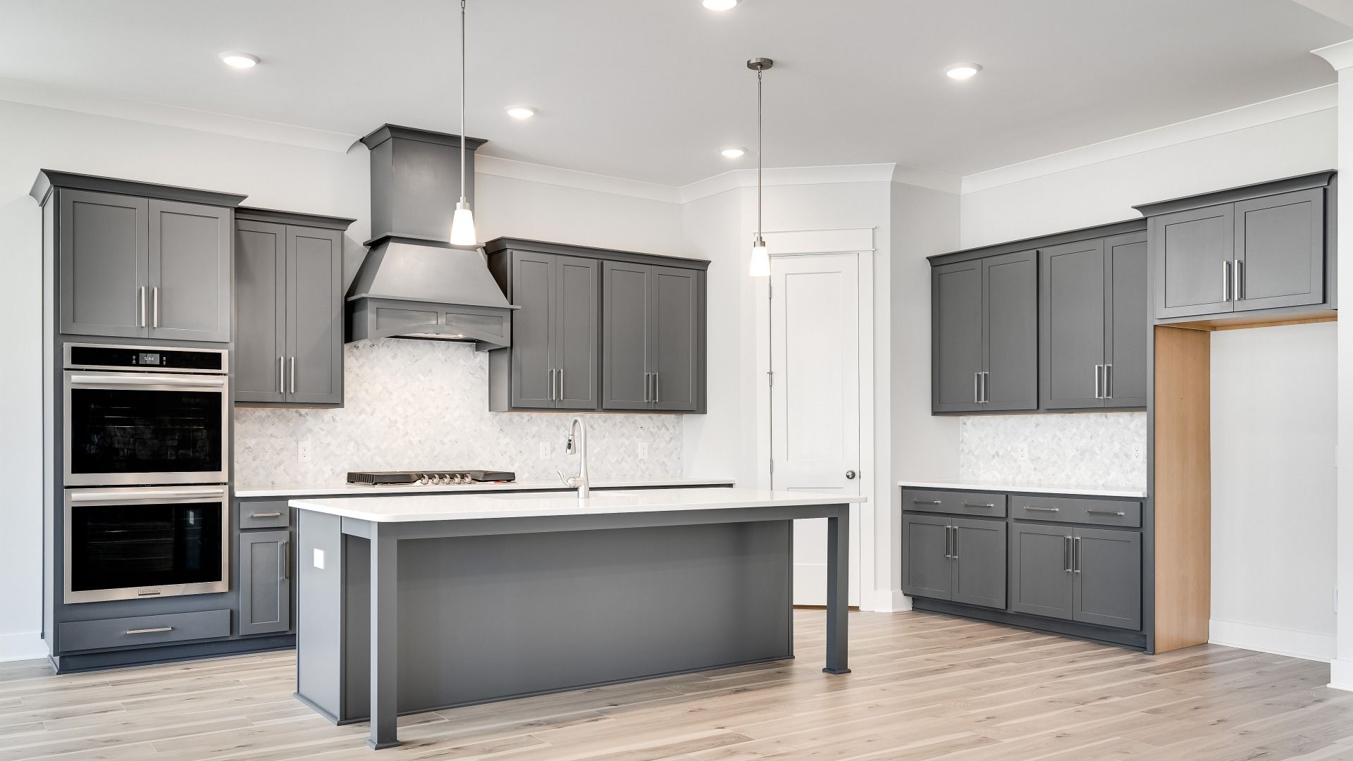L-shaped Kitchen with corner pantry with gray cabinets and modern style with tile backsplash and range hood