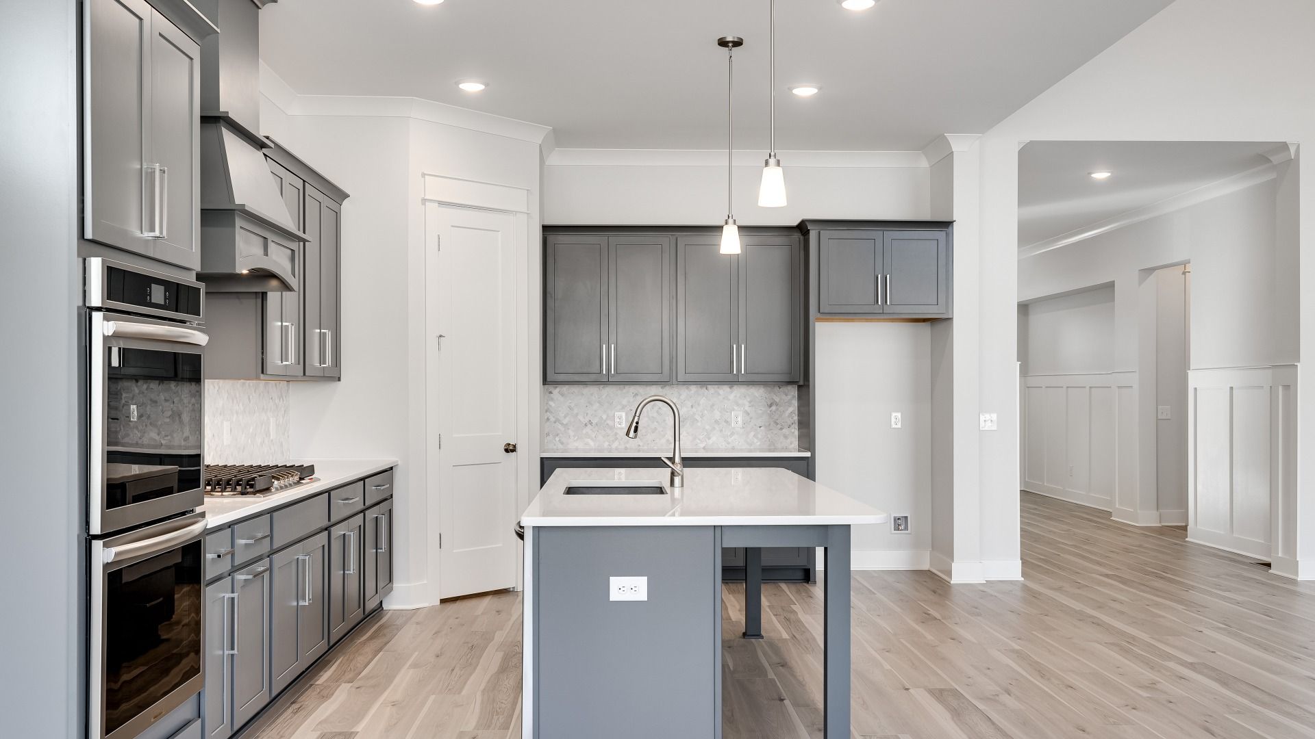 L-shaped Kitchen with corner pantry with gray cabinets and modern style with tile backsplash and range hood