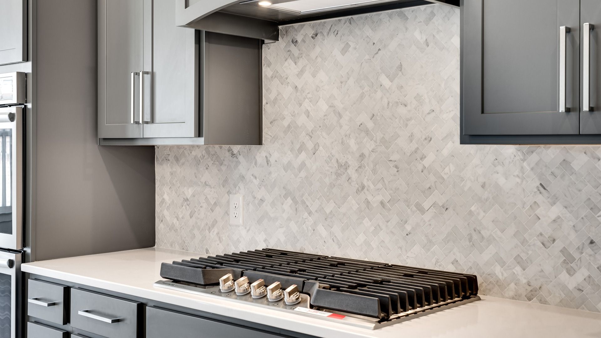 Gas range with designer backsplash and gray cabinetry