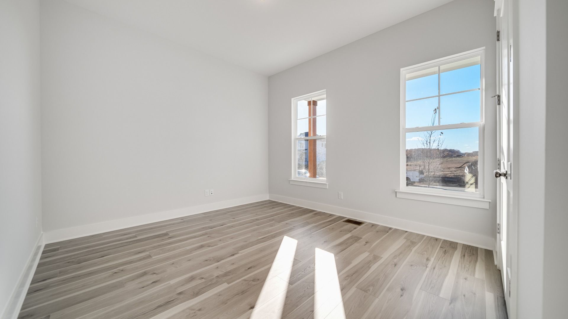 Secondary Bedroom with multiple windows and wood flooring