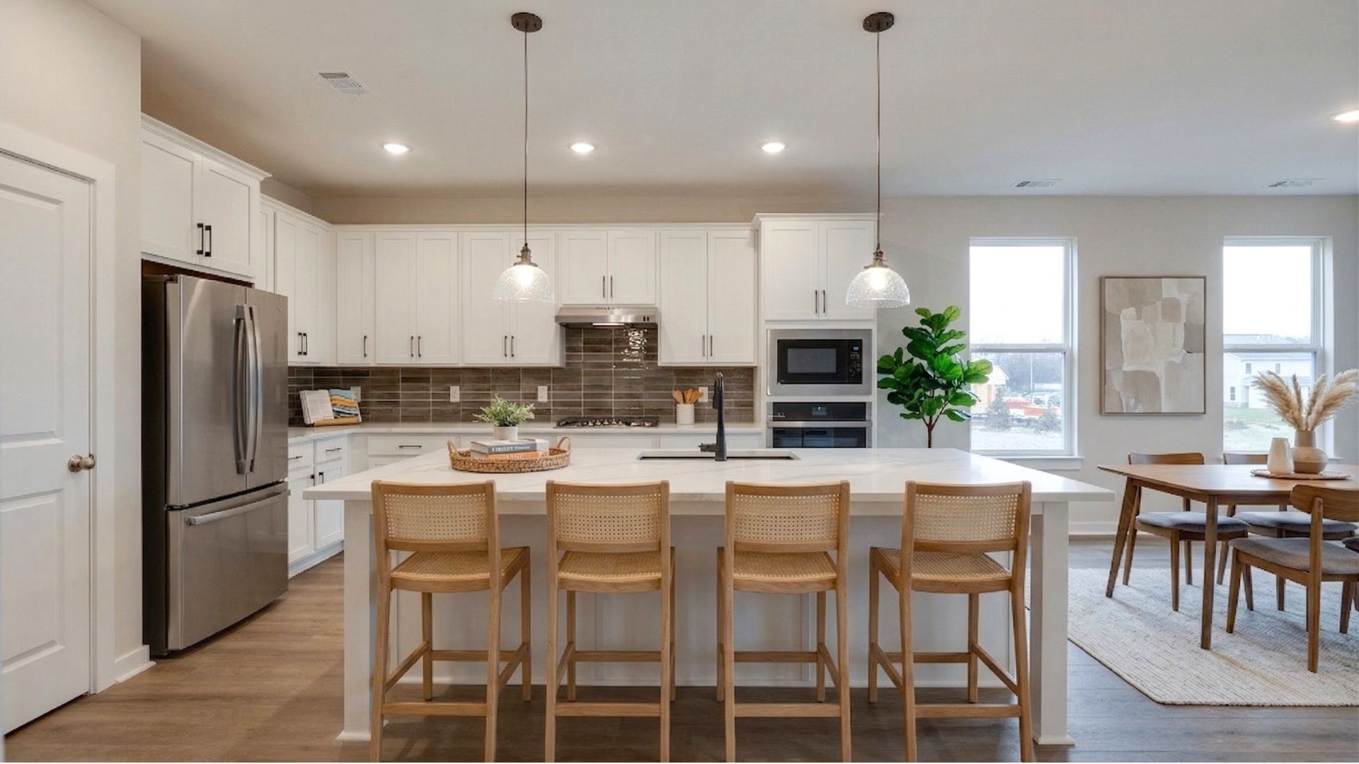 Virtually staged kitchen with barstool seating at the island and dining area to the side
