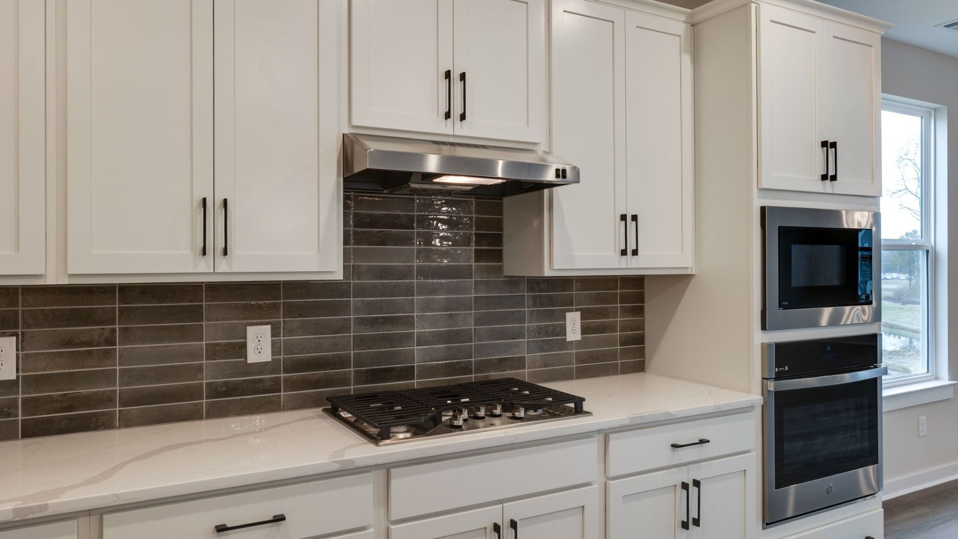 Kitchen with large island, accent tile backsplash, double wall ovens, pantry
