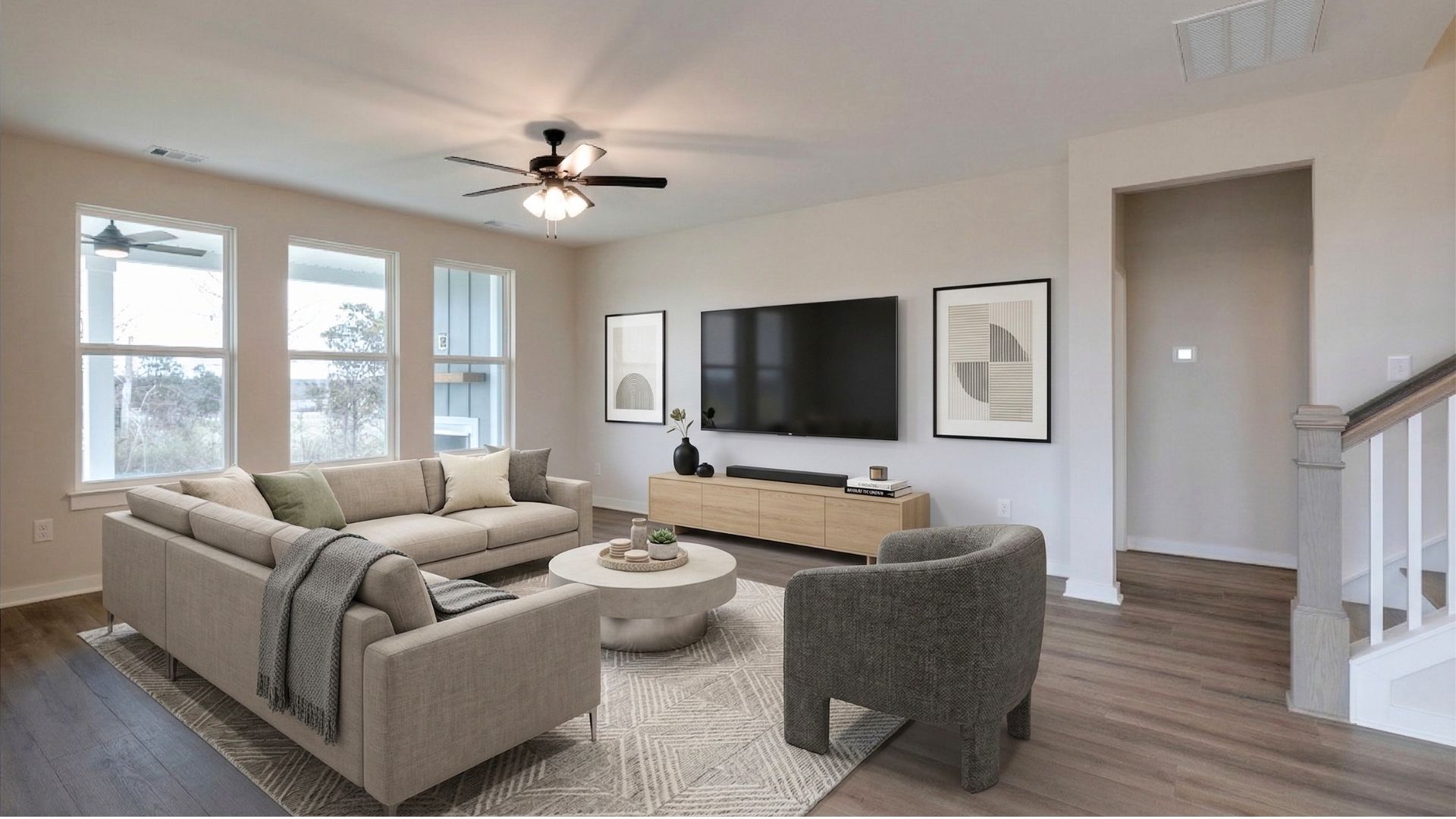 Living room setup in cozy nook with bright natural light from nearby windows and primary bedroom and second floor access