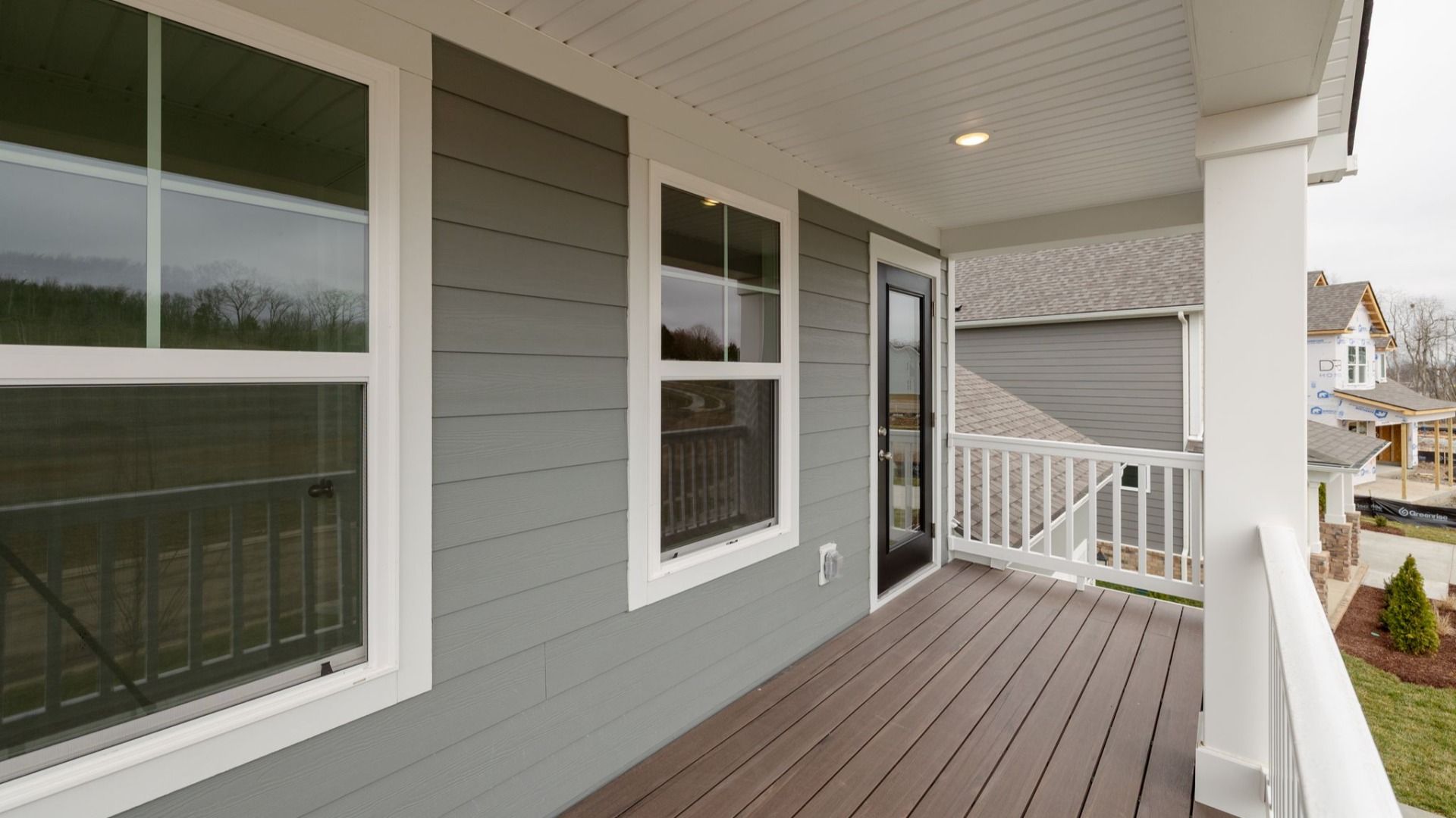 Covered balcony with fencing and columns, accessed from second floor