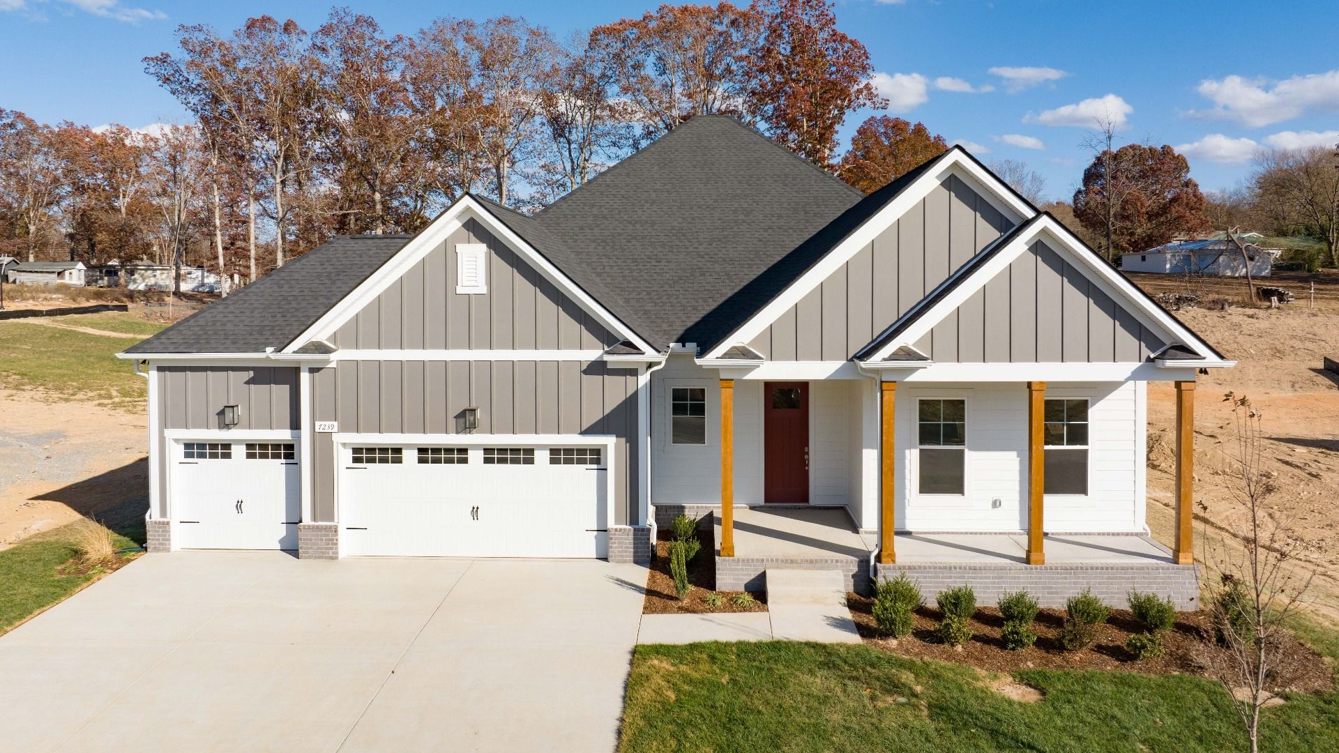 Exterior of home with white and gray siding and wood accent columns around covered front porch