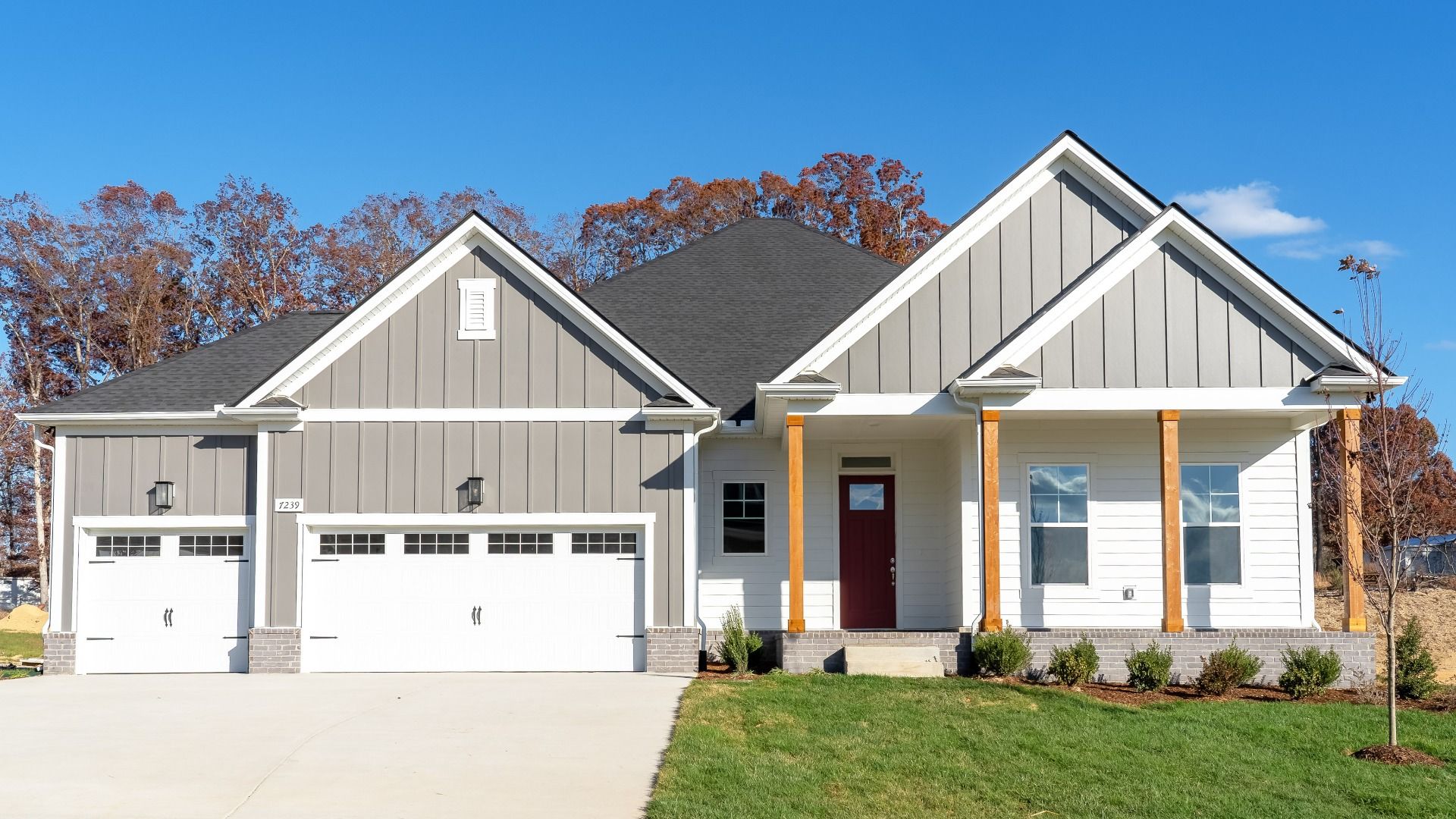 Exterior of home with white and gray siding and wood accent columns around covered front porch