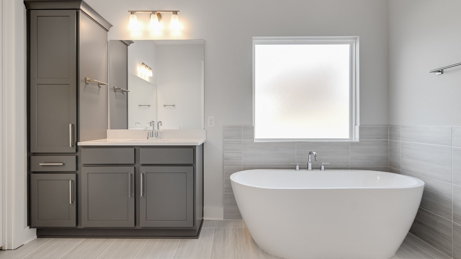 Large tiled bathroom with multiple vanities, glass shower enclosure, and freestanding tub