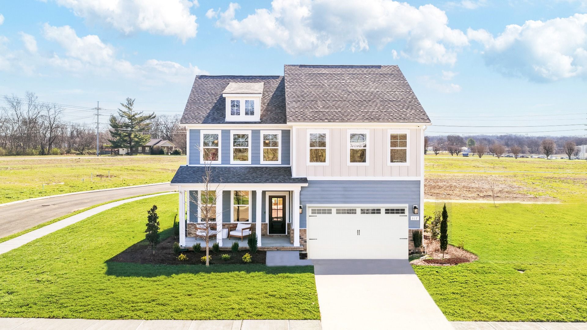 Home exterior with blue siding and white accents and covered front porch