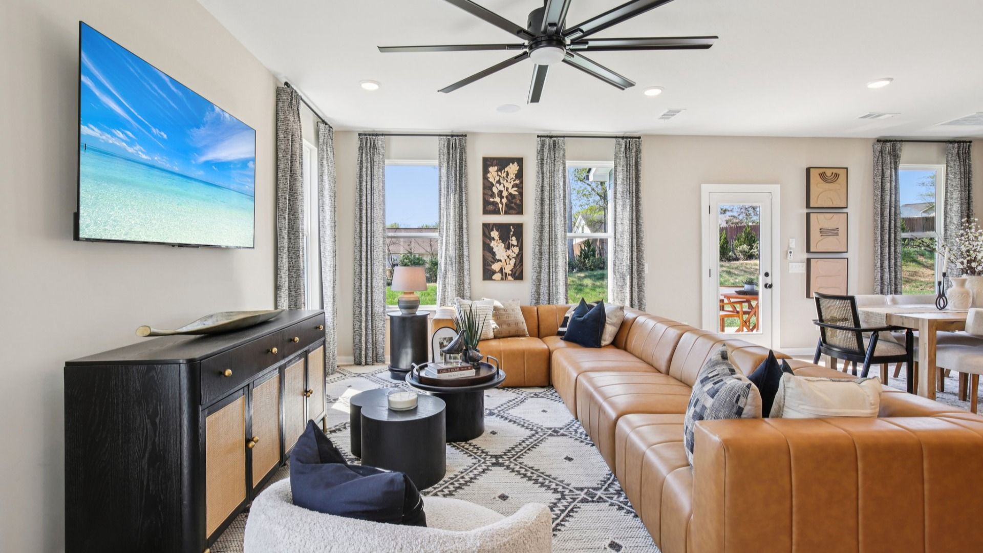 First floor living room with leather couch and large fan