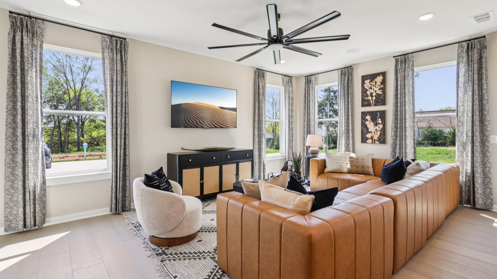 First floor living room with leather couch and large fan