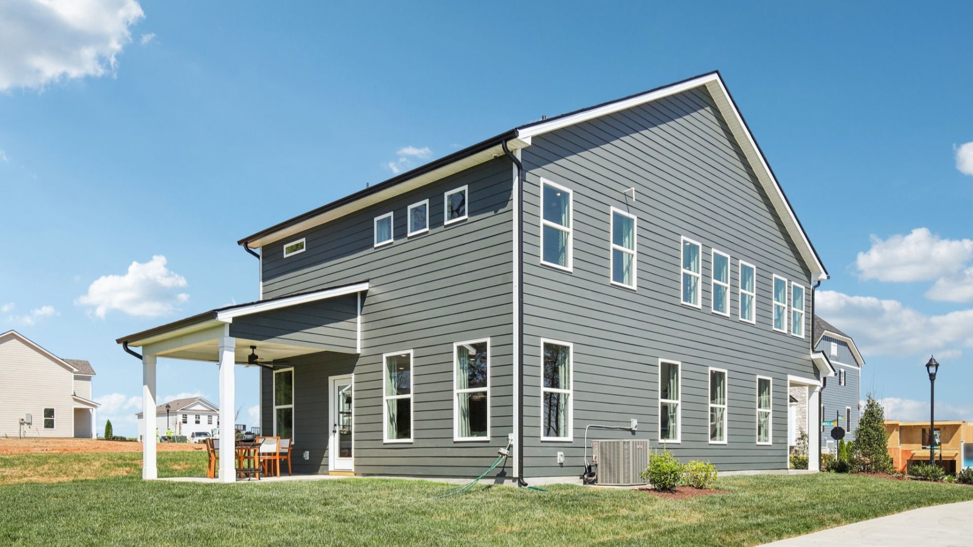 View of home from the side showing covered back patio and array of windows